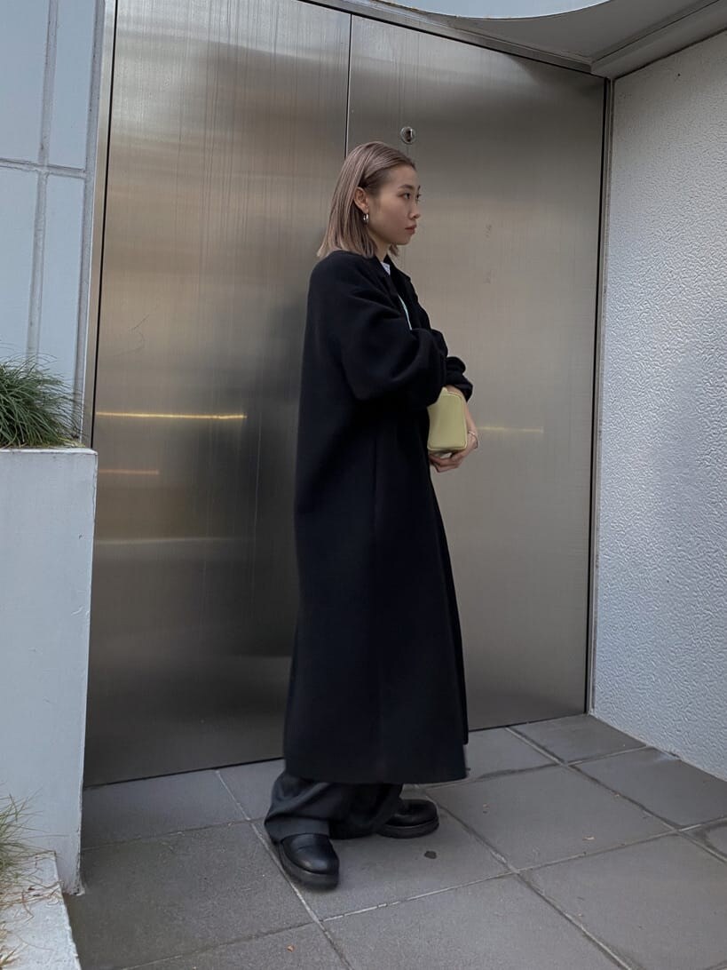 ブラック系のチェスターコート、グレー系のその他パンツ、グレー系のTシャツ/カットソーを着用したレディースの秋コーディネートの3枚目の写真