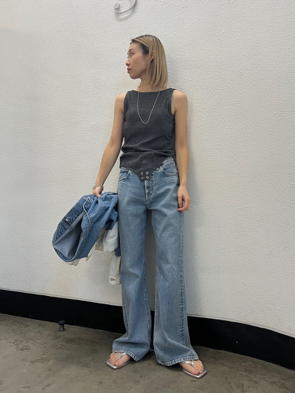 ブルー系のデニムパンツ、シルバー系のサンダル、グレー系のタンクトップを着用したレディースの冬コーディネートの2枚目の写真