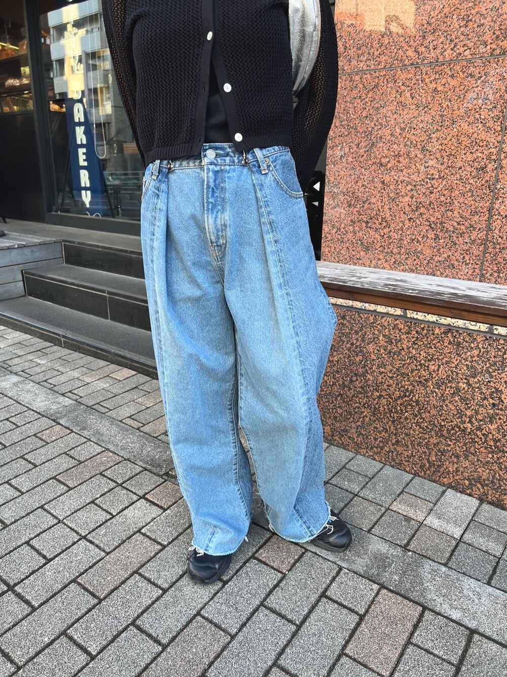 ブルー系のデニムパンツ、ブラック系のスニーカー、ブラック系のカーディガン/ボレロを着用したレディースの春コーディネートの2枚目の写真