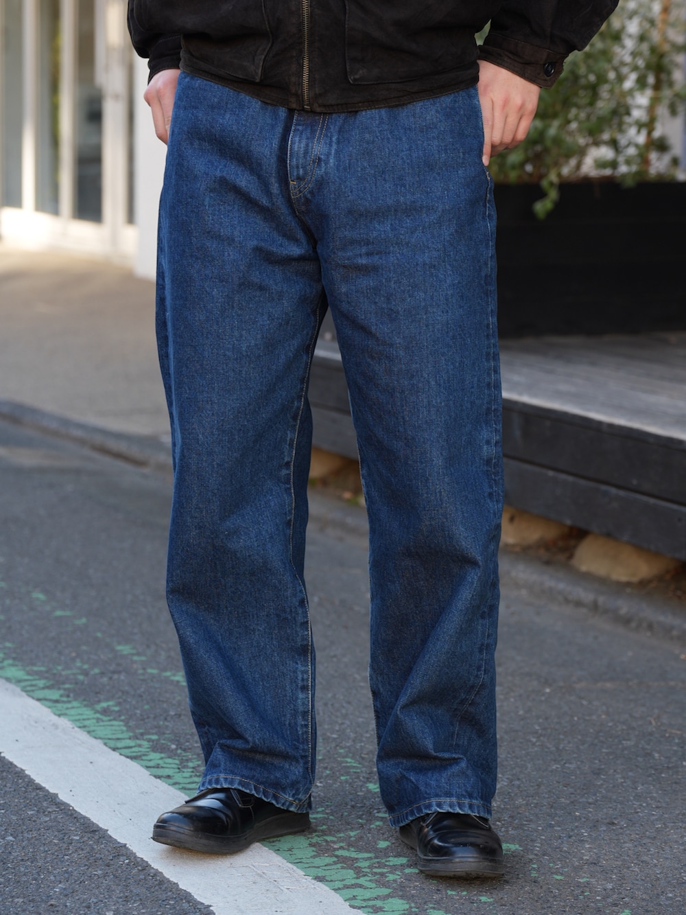 ブルー系のデニムパンツ、ブラック系のドレスシューズ、ブラック系のジャケット/アウターを着用したメンズの冬コーディネートの3枚目の写真