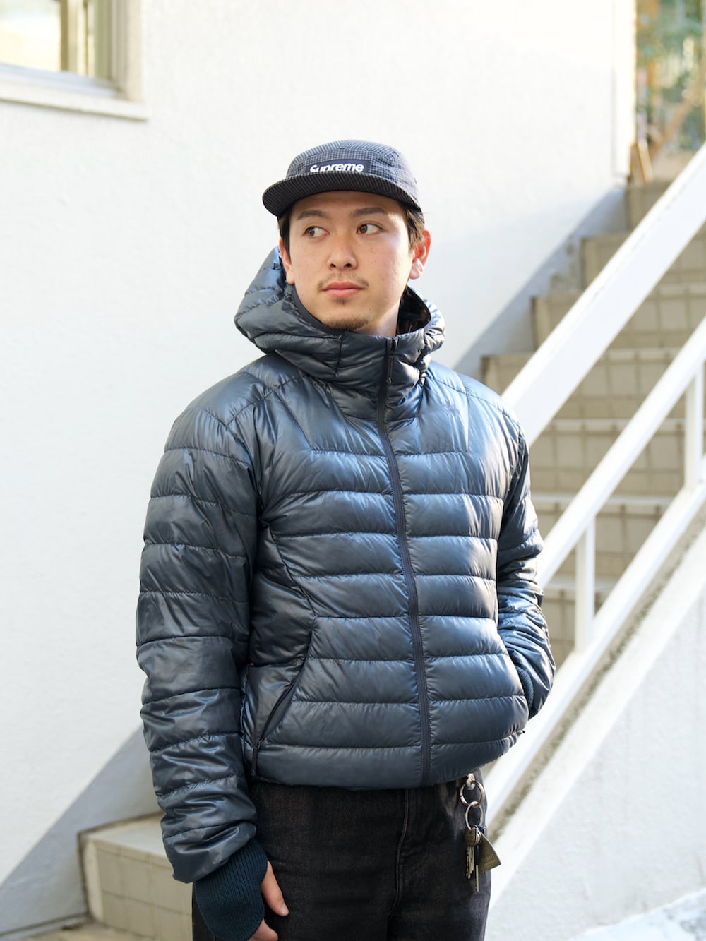 ブラック系のデニムパンツ、グレー系のダウンジャケット/コート、ブラック系のスニーカーを着用したメンズの冬コーディネートの3枚目の写真