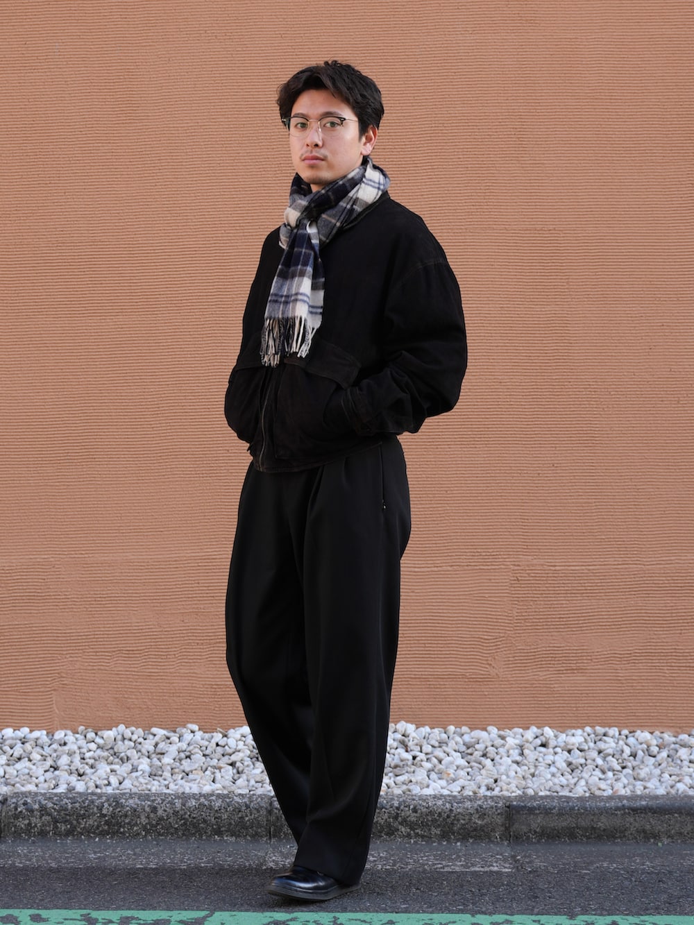 ブラック系のドレスシューズ、ブラック系のジャケット/アウター、ブラック系のスラックスを着用したメンズの春コーディネートの2枚目の写真