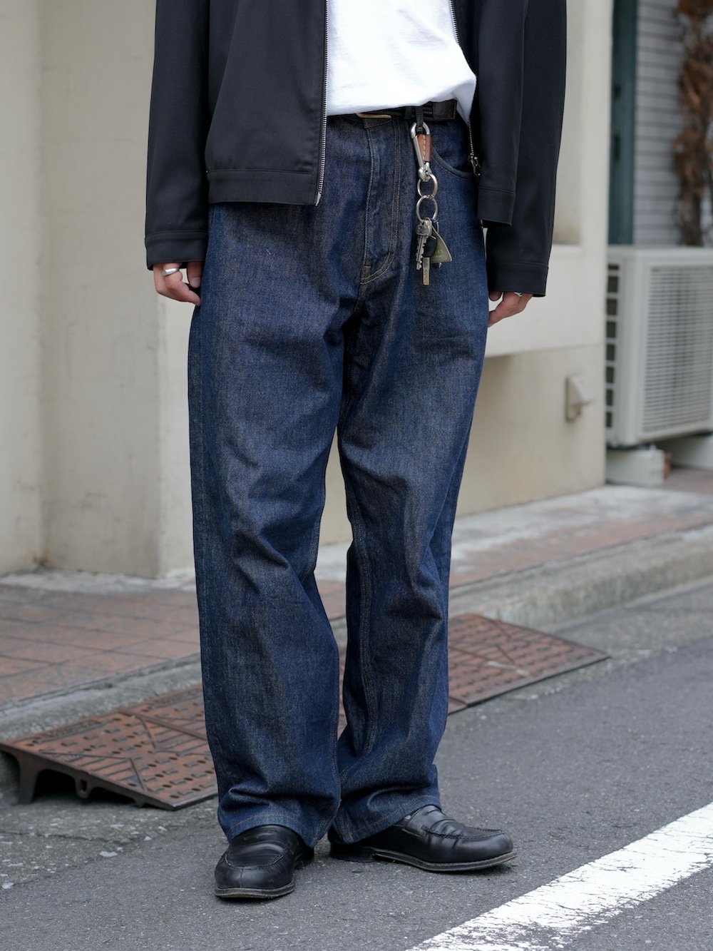 ホワイト系のTシャツ/カットソー、ブラック系のローファー、ブルー系のデニムパンツを着用したメンズの秋コーディネートの4枚目の写真