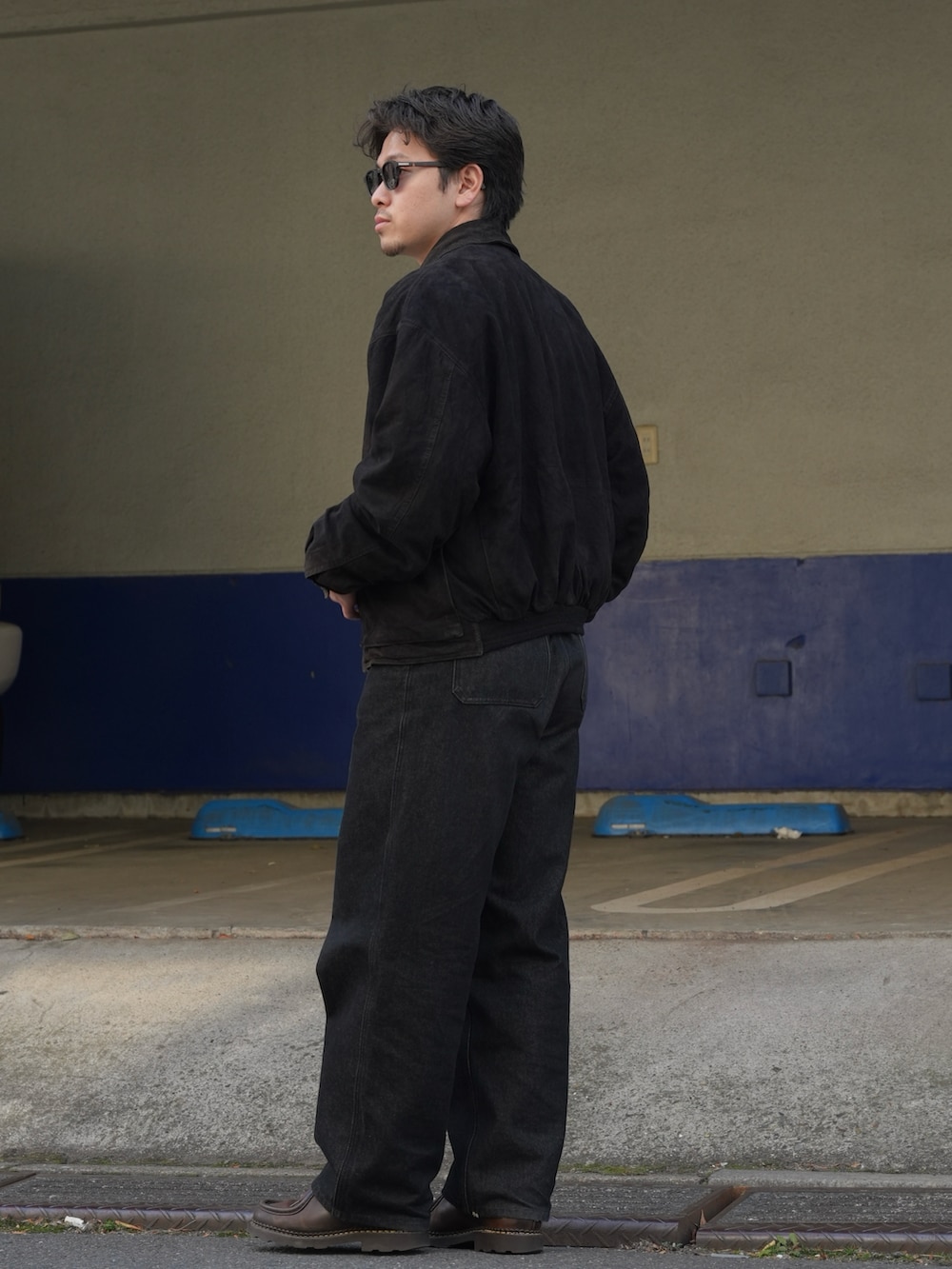 ブラック系のデニムパンツ、ホワイト系のニット/セーター、ブラック系のジャケット/アウターを着用したメンズの春コーディネートの2枚目の写真