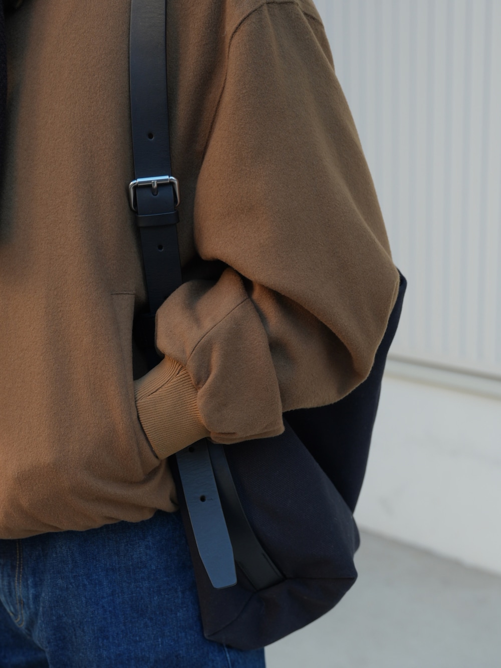 ブルー系のデニムパンツ、ベージュ系のジャケット/アウター、ブルー系のメッセンジャーバッグを着用したメンズの春コーディネートの4枚目の写真