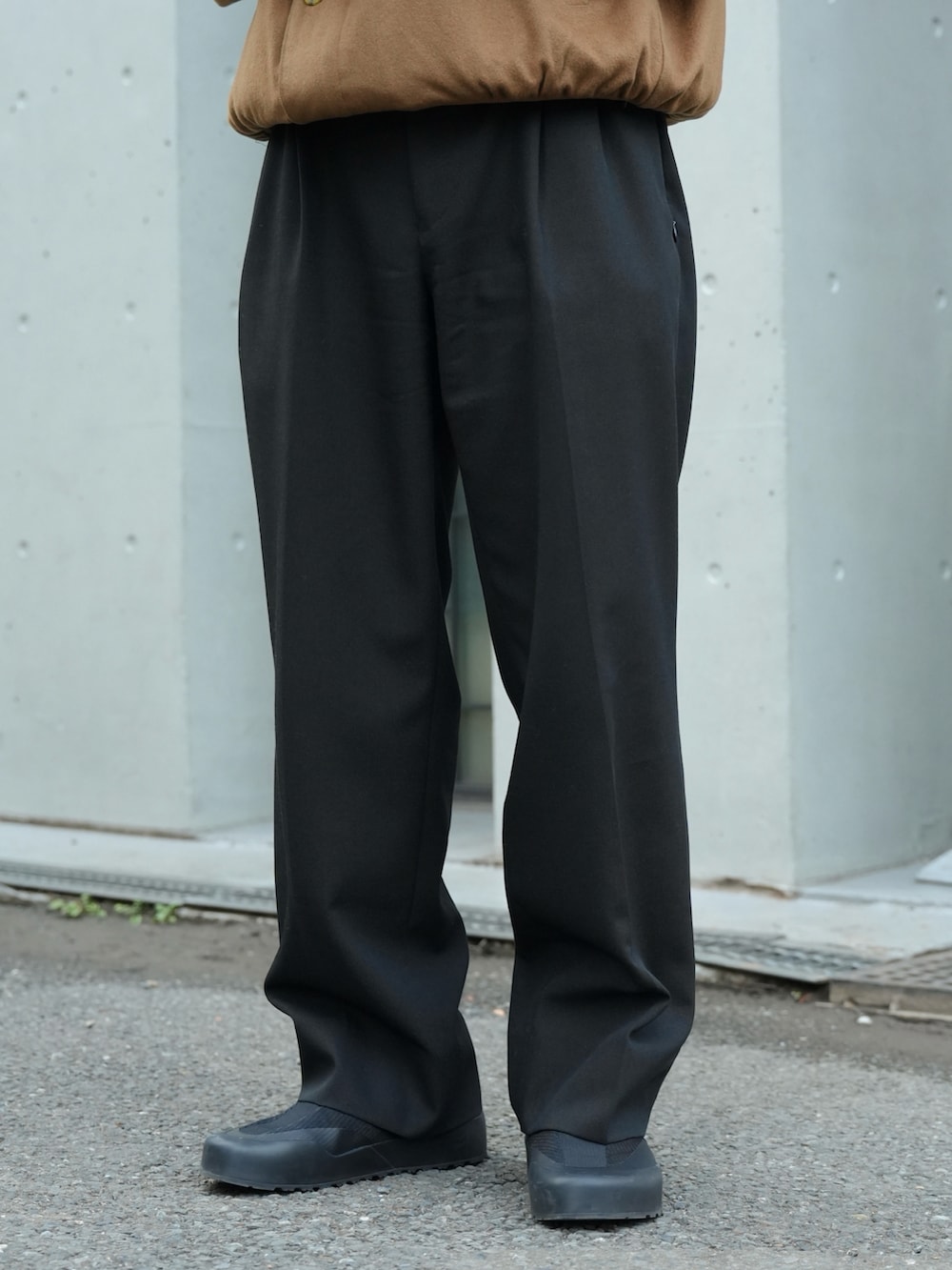 ブラック系のスニーカー、ベージュ系のジャケット/アウター、ブラック系のスラックスを着用したメンズの冬コーディネートの4枚目の写真