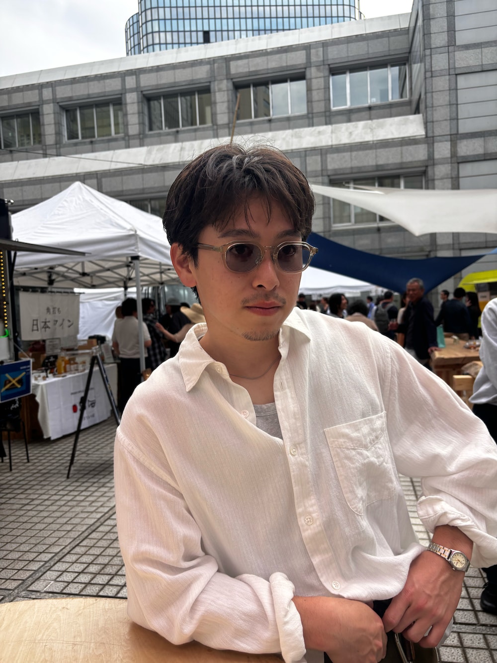 ブラック系のスニーカー、ホワイト系のシャツ/ブラウス、グリーン系のチノパンツを着用したメンズの春コーディネートの2枚目の写真
