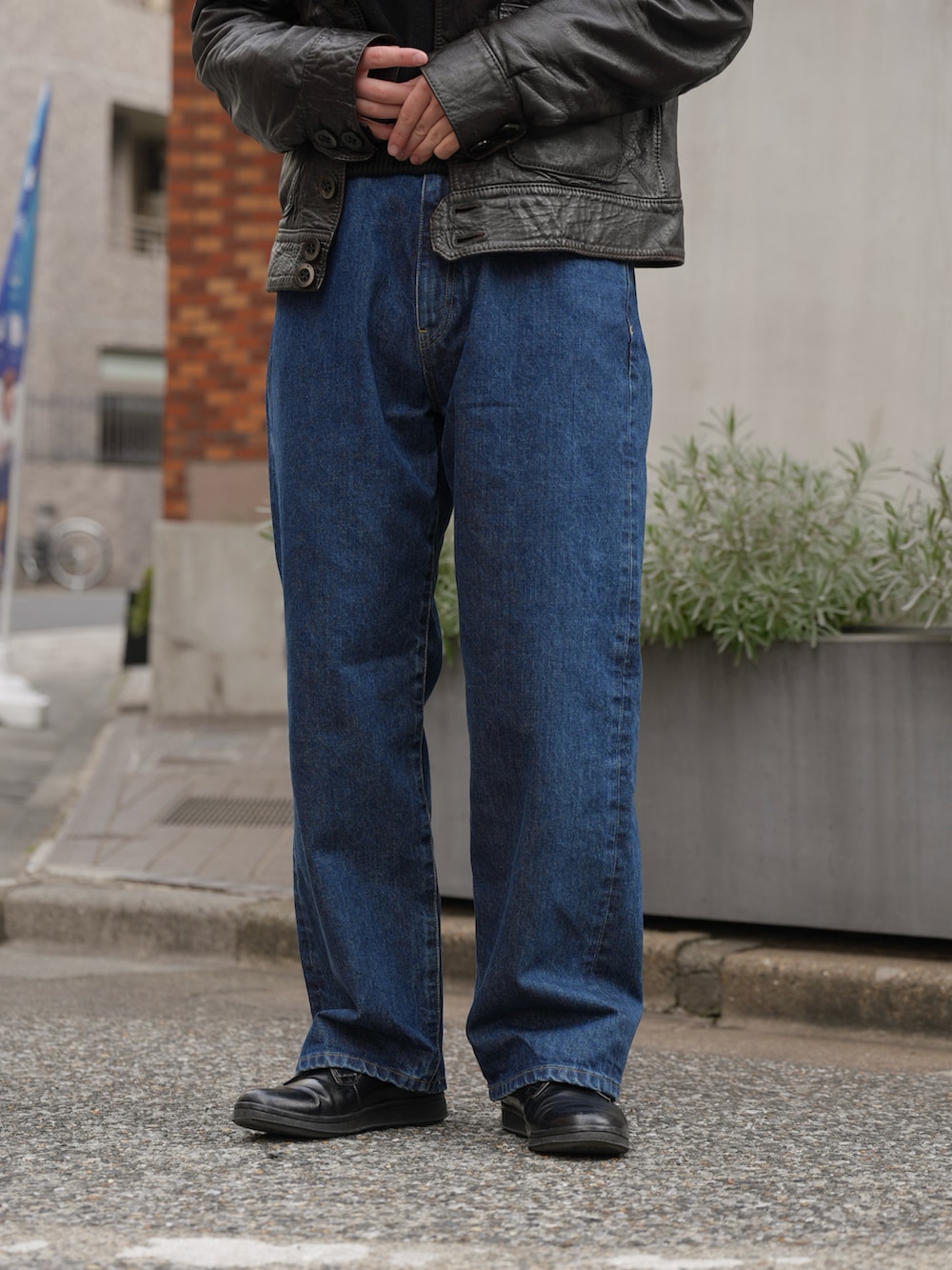 ブルー系のデニムパンツ、ブラック系のジャケット/アウター、ブラウン系のサングラスを着用したメンズの春コーディネートの3枚目の写真