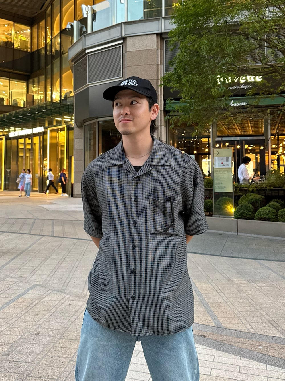 ブルー系のデニムパンツ、ブラック系のドレスシューズ、ブラック系のシャツ/ブラウスを着用したメンズの夏コーディネートの2枚目の写真