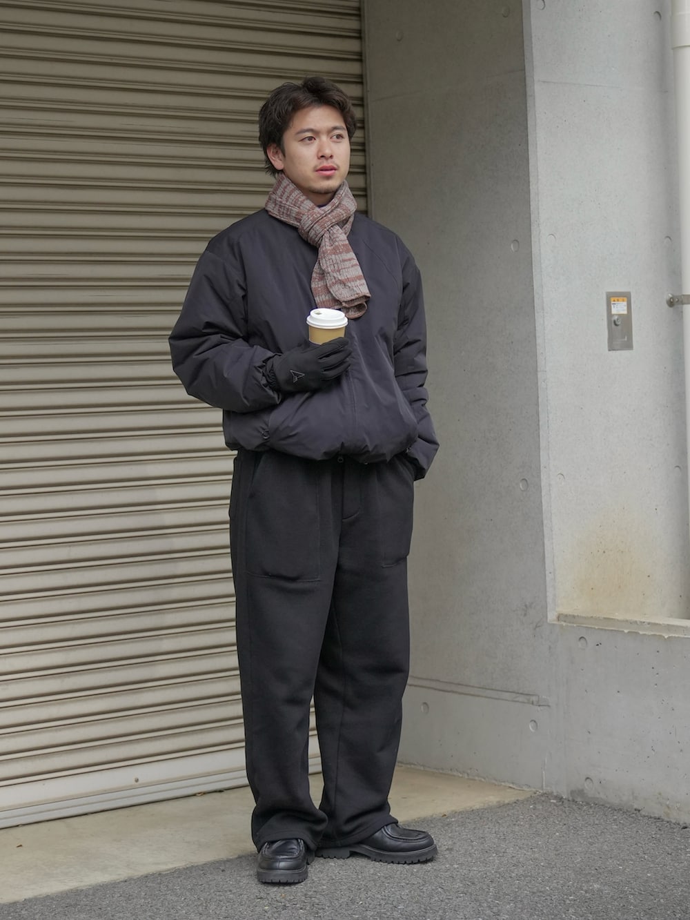 ブラック系のパンツ、ブラック系のモカシン/デッキシューズ、ブラック系のジャケット/アウターを着用したメンズの冬コーディネートの2枚目の写真