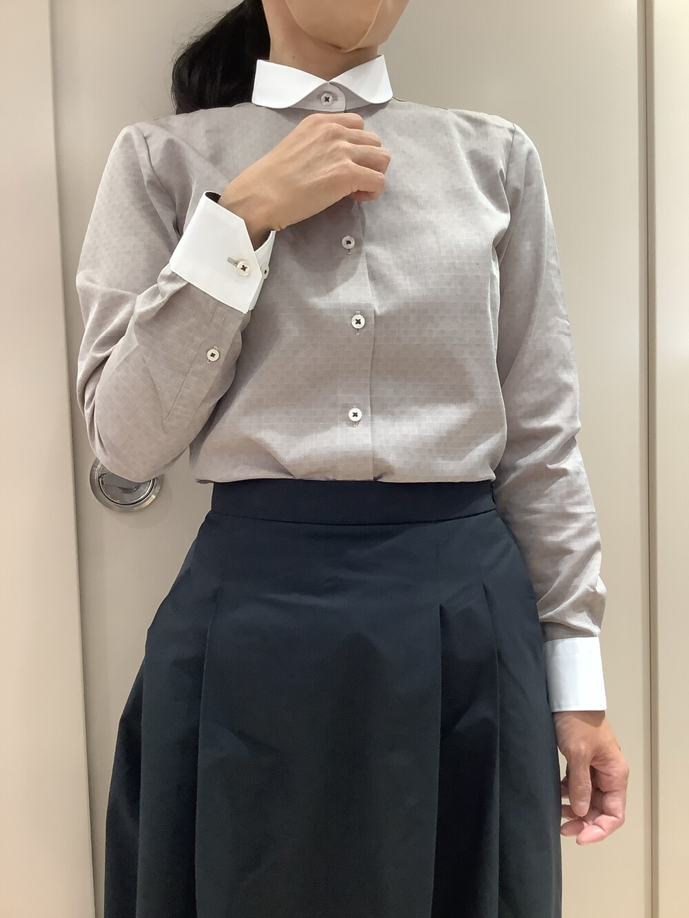 ブラウン系のビジネスシャツを着用したレディースの秋コーディネートの2枚目の写真