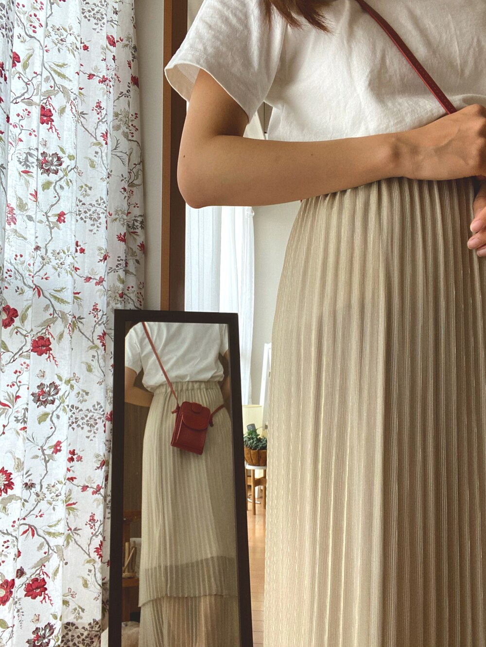 ベージュ系のスカート、ホワイト系のTシャツ/カットソー、オレンジ系のショルダーバッグを着用したレディースの夏コーディネートの4枚目の写真