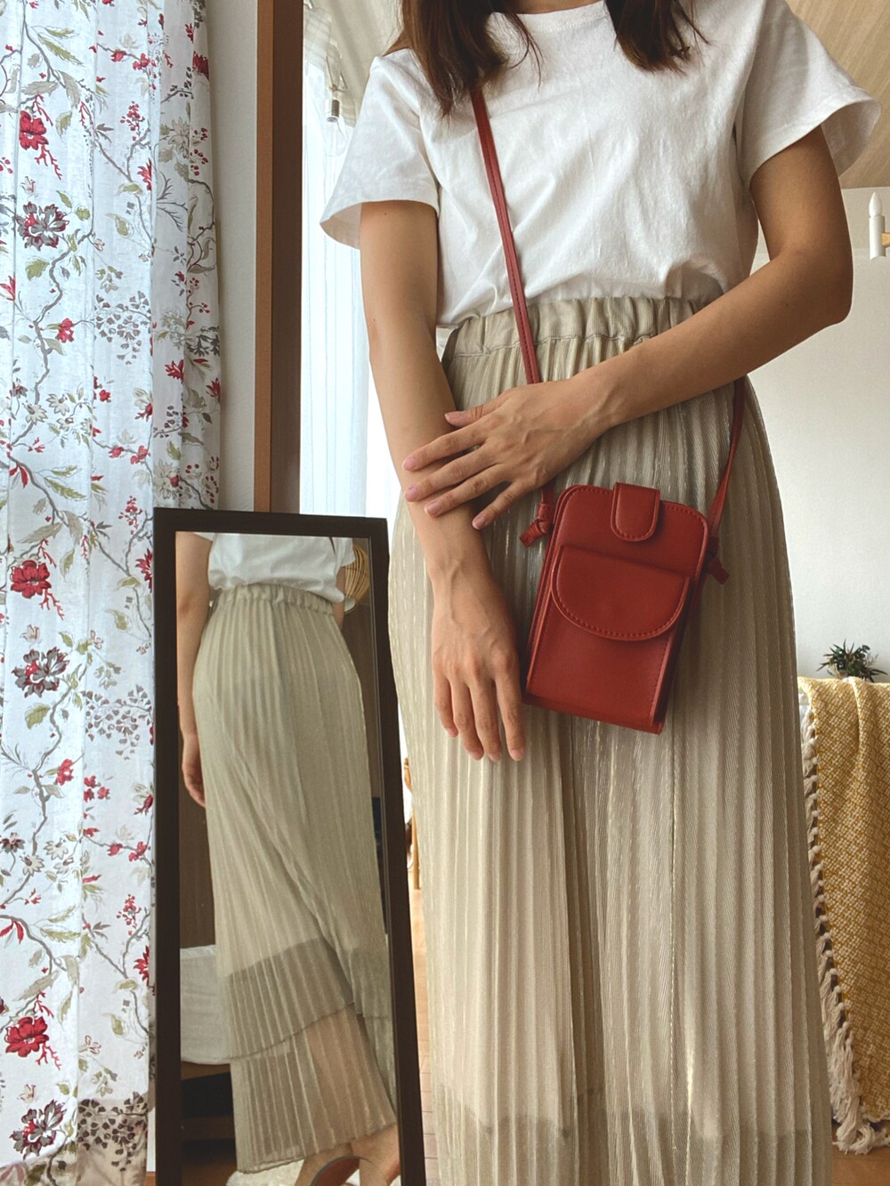 ベージュ系のスカート、ホワイト系のTシャツ/カットソー、オレンジ系のショルダーバッグを着用したレディースの夏コーディネートの2枚目の写真