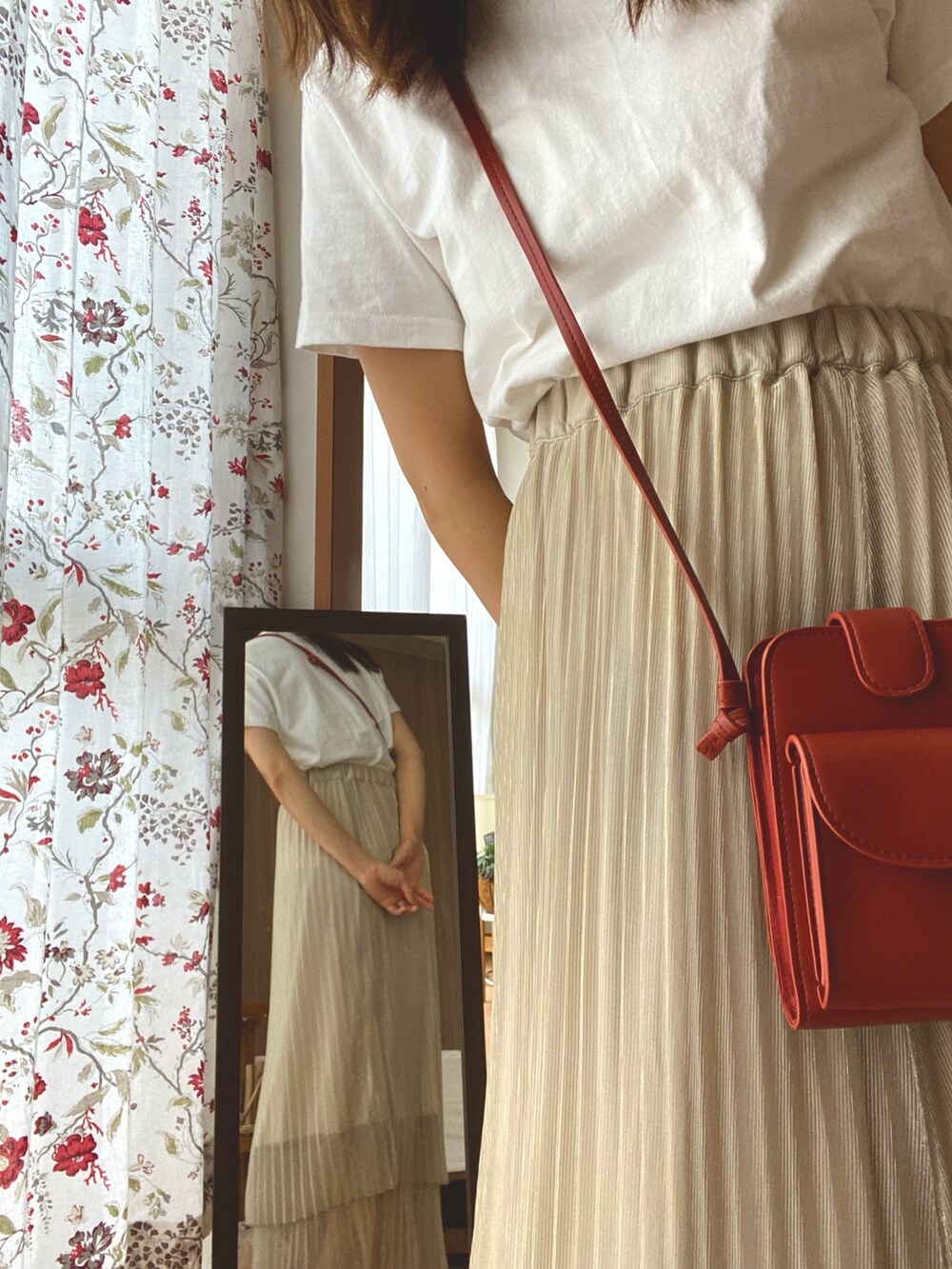 ベージュ系のスカート、ホワイト系のTシャツ/カットソー、オレンジ系のショルダーバッグを着用したレディースの夏コーディネートの3枚目の写真