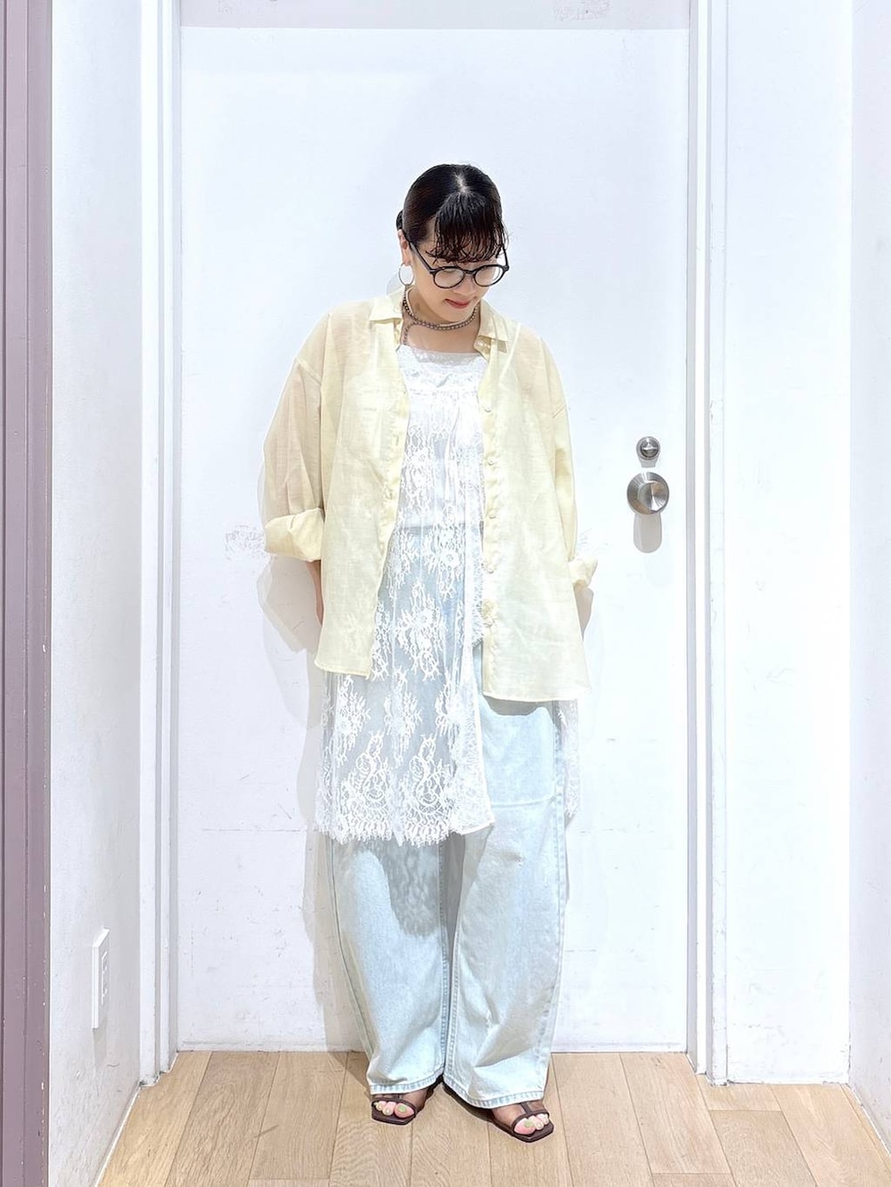 イエロー系のシャツ/ブラウス、ブルー系のデニムパンツ、ブラウン系のサンダルを着用したレディースの夏コーディネートの5枚目の写真