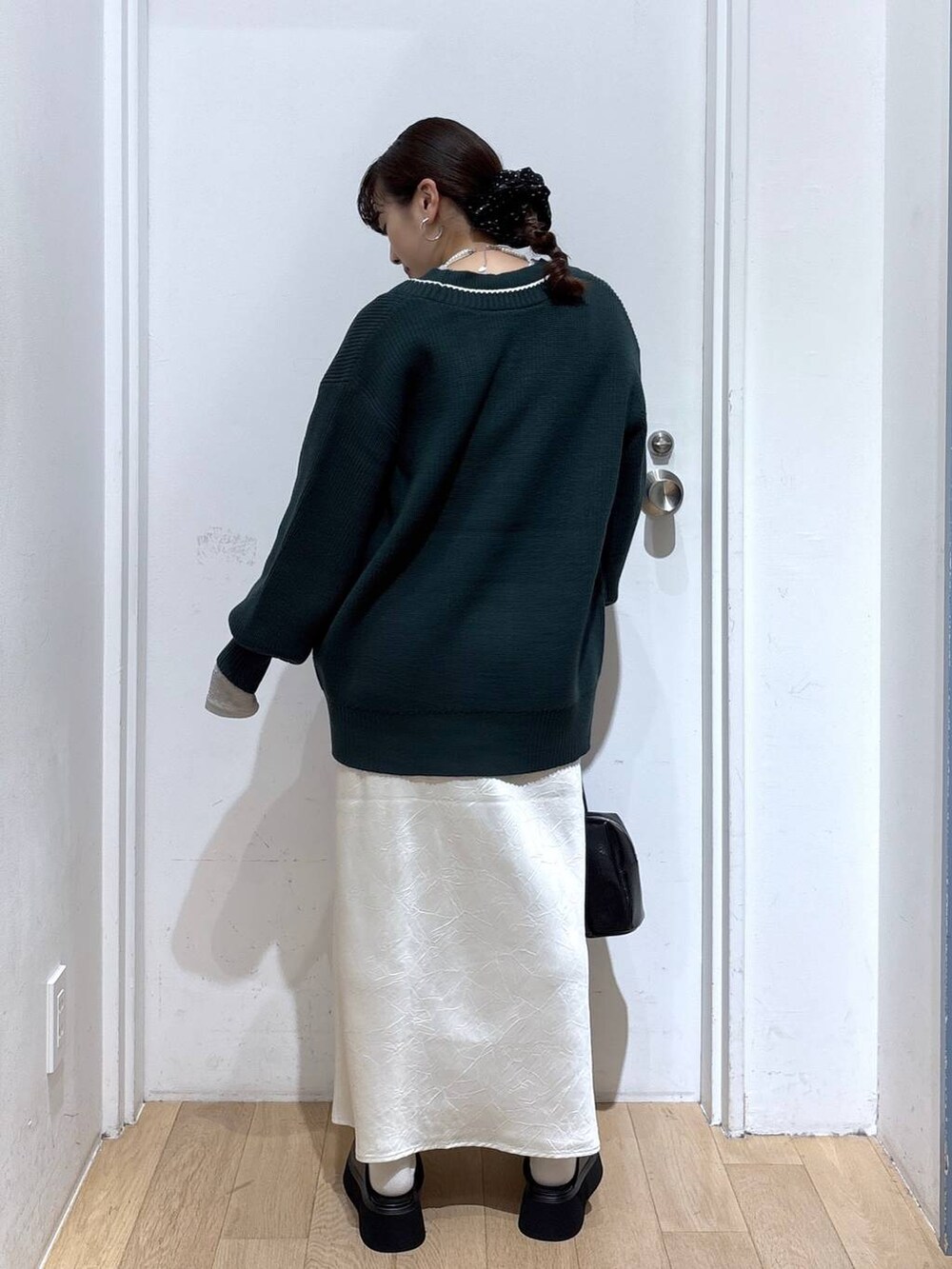 ホワイト系のスカート、グリーン系のカーディガン/ボレロ、ブラック系のボストンバッグを着用したレディースの秋コーディネートの4枚目の写真