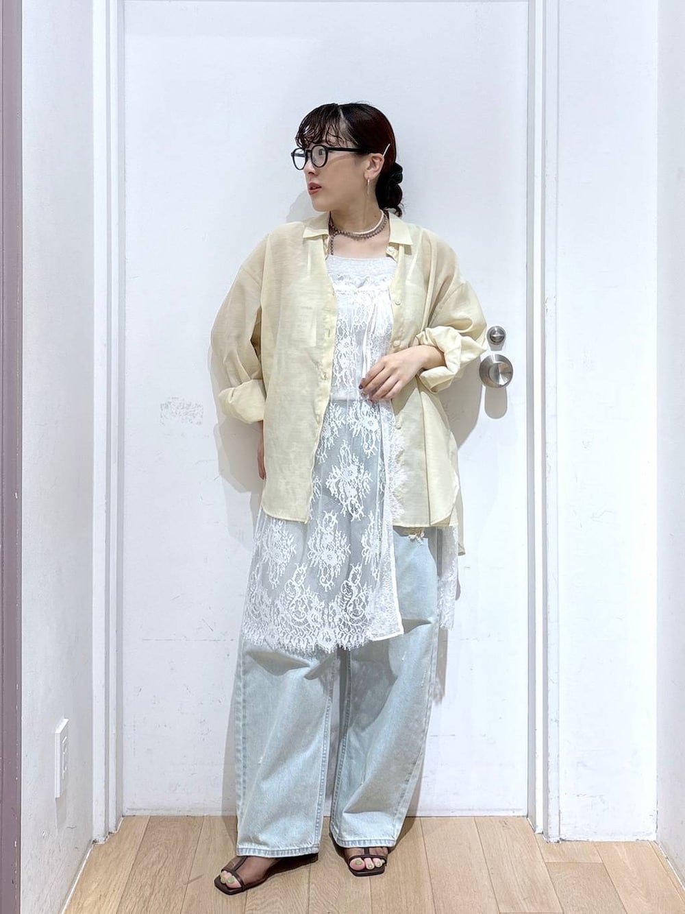 イエロー系のシャツ/ブラウス、ブルー系のデニムパンツ、ブラウン系のサンダルを着用したレディースの夏コーディネートの4枚目の写真