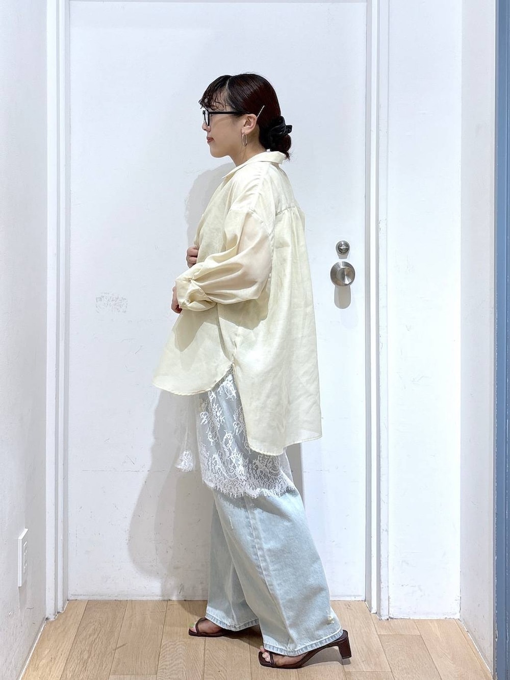 イエロー系のシャツ/ブラウス、ブルー系のデニムパンツ、ブラウン系のサンダルを着用したレディースの夏コーディネートの2枚目の写真