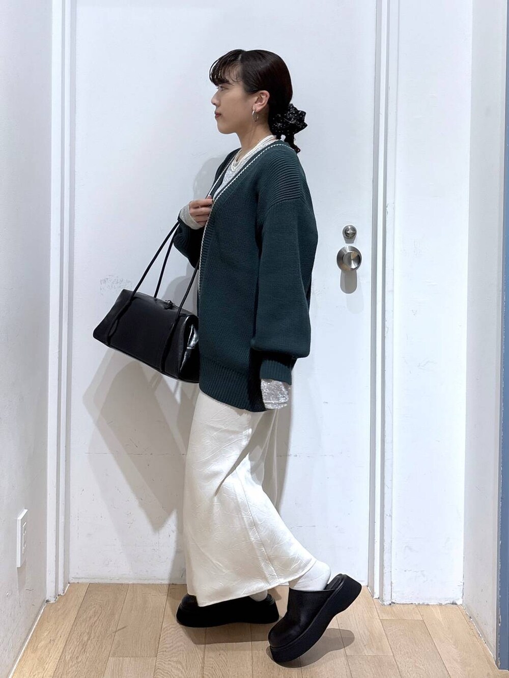 ホワイト系のスカート、グリーン系のカーディガン/ボレロ、ブラック系のボストンバッグを着用したレディースの秋コーディネートの3枚目の写真
