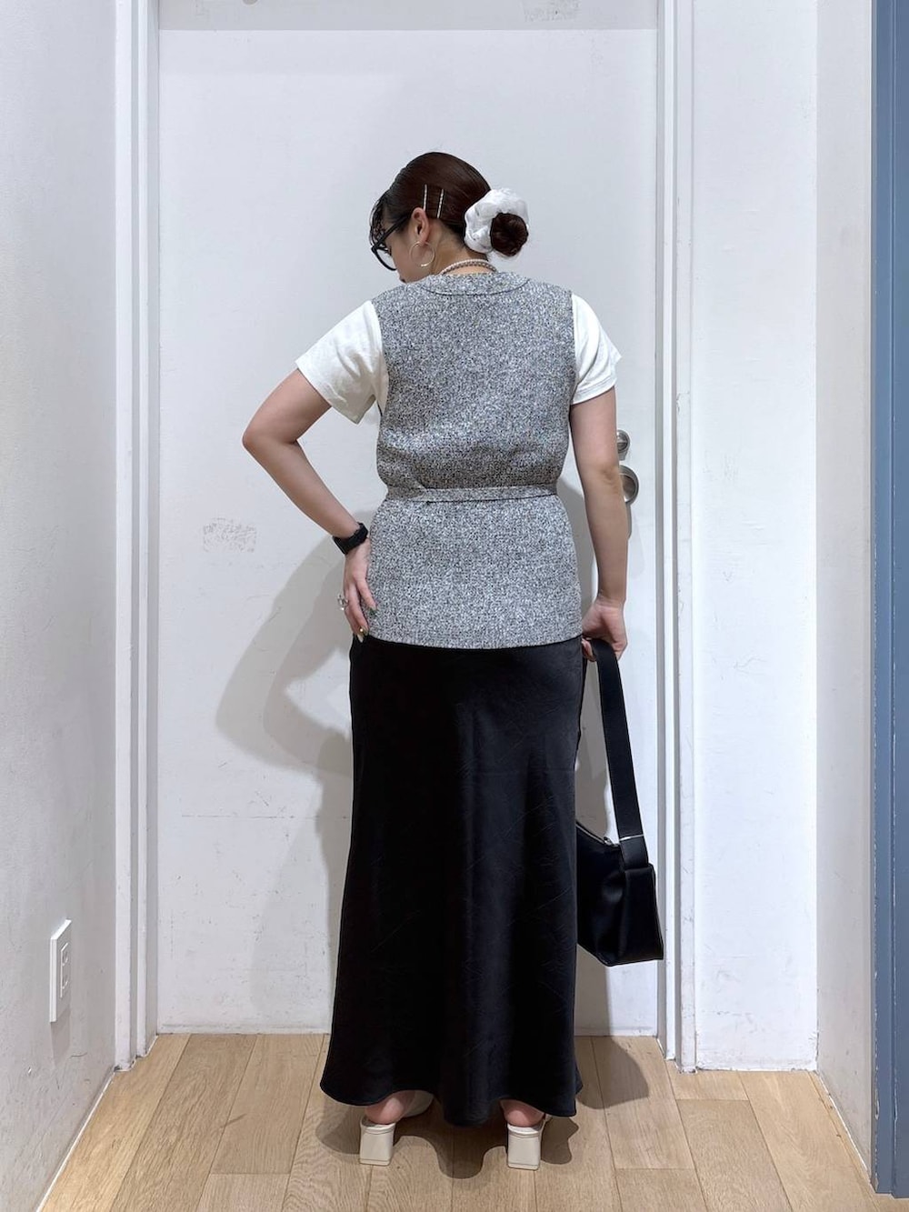 ブラック系のスカート、ホワイト系のTシャツ/カットソー、ブラック系のショルダーバッグを着用したレディースの春コーディネートの4枚目の写真