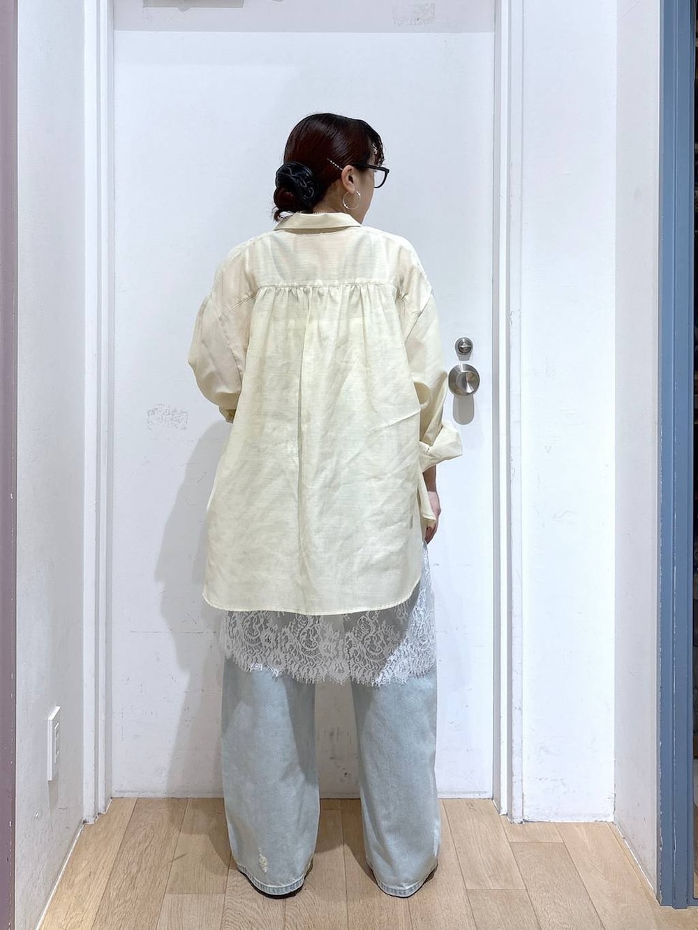 イエロー系のシャツ/ブラウス、ブルー系のデニムパンツ、ブラウン系のサンダルを着用したレディースの夏コーディネートの3枚目の写真