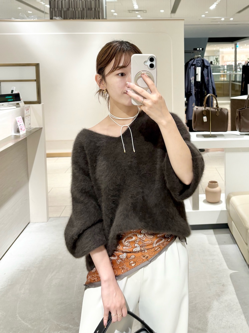 ブラウン系のニット/セーター、ブラック系のその他シューズ、ブラック系のトートバッグを着用したレディースの秋コーディネートの2枚目の写真