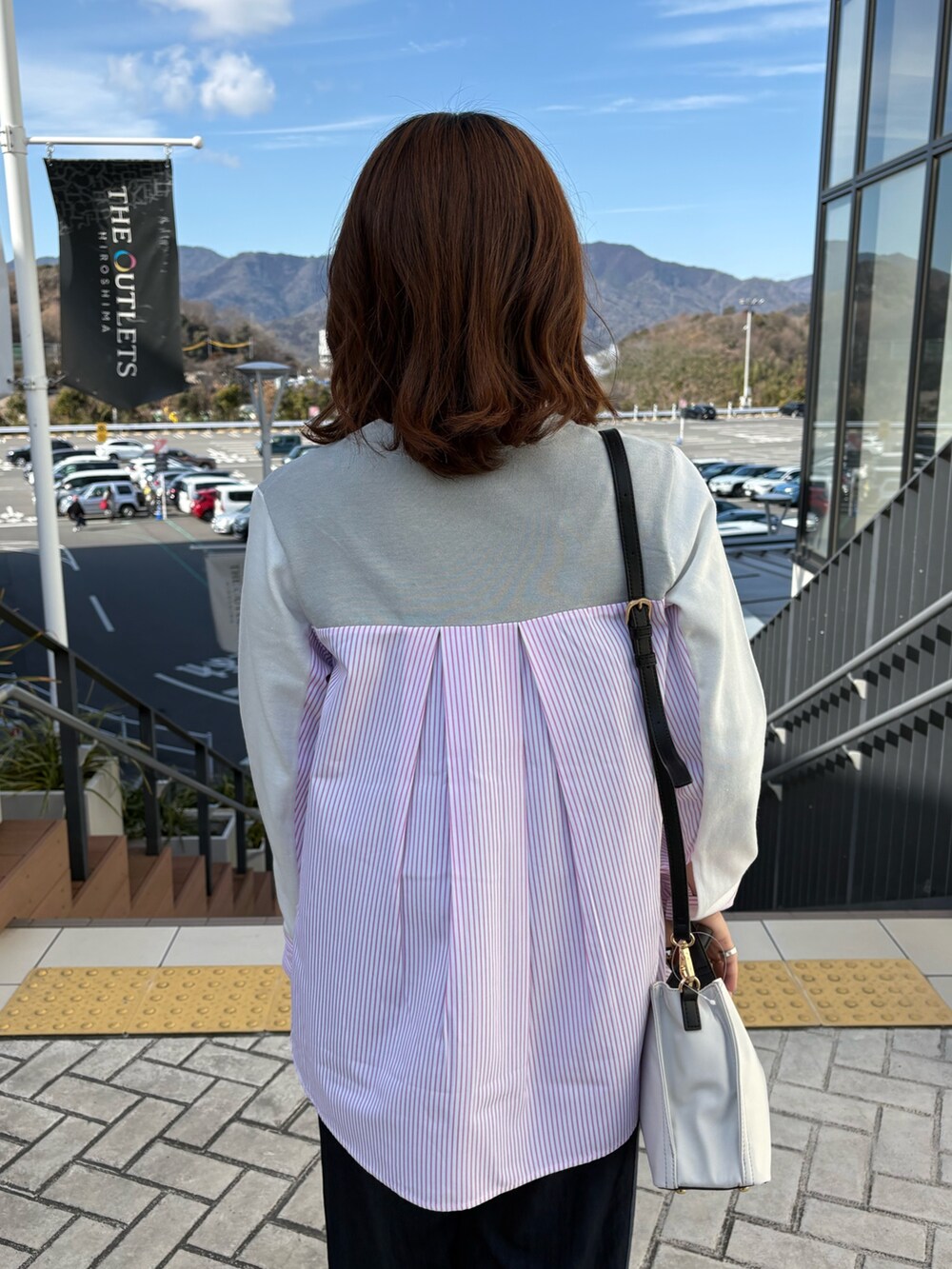 グレー系のニット/セーター、ブルー系のデニムパンツを着用したレディースの冬コーディネートの6枚目の写真