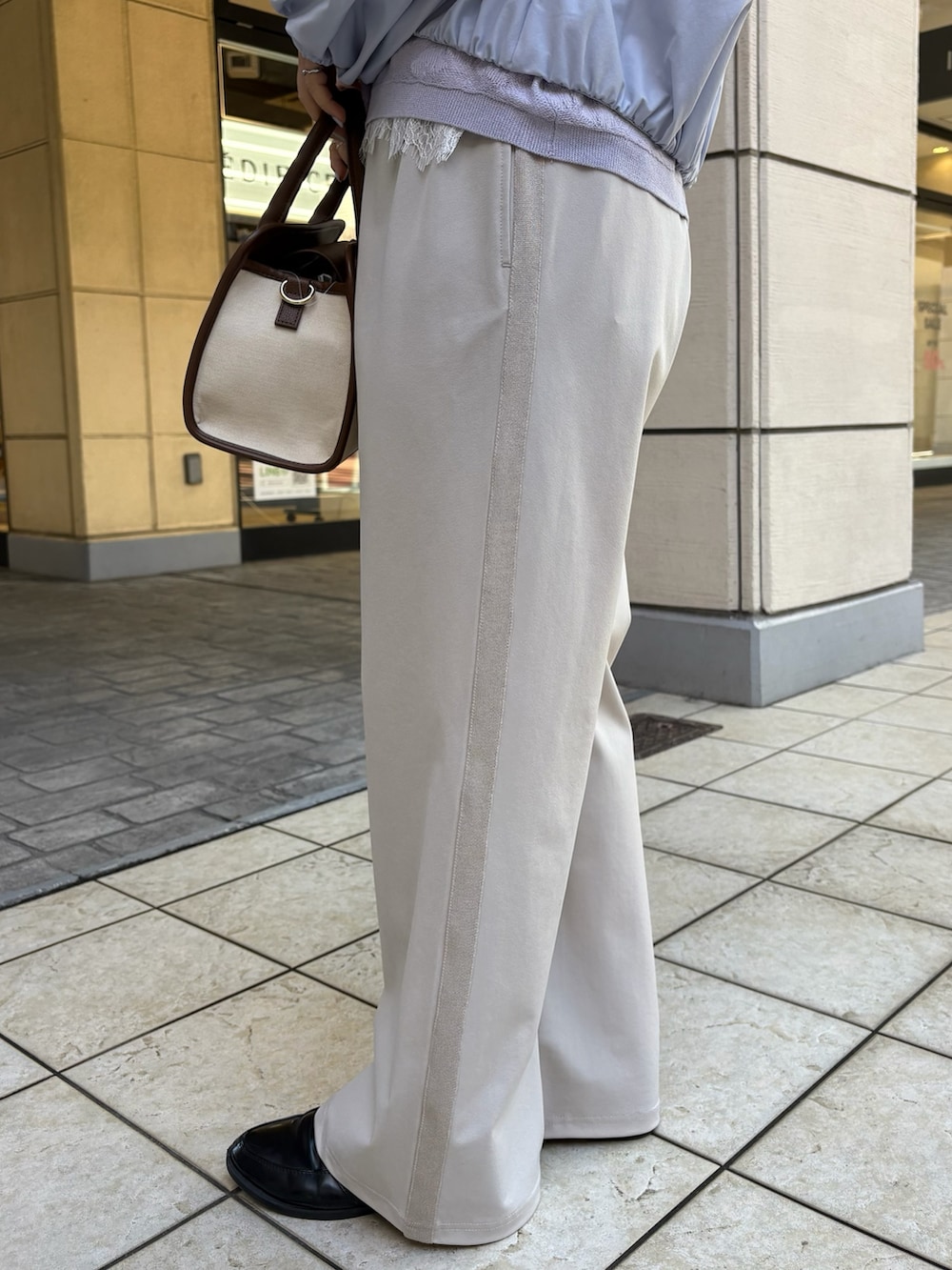 ブルー系のブルゾン、パープル系のニット/セーター、ホワイト系のTシャツ/カットソーを着用したレディースの春コーディネートの8枚目の写真