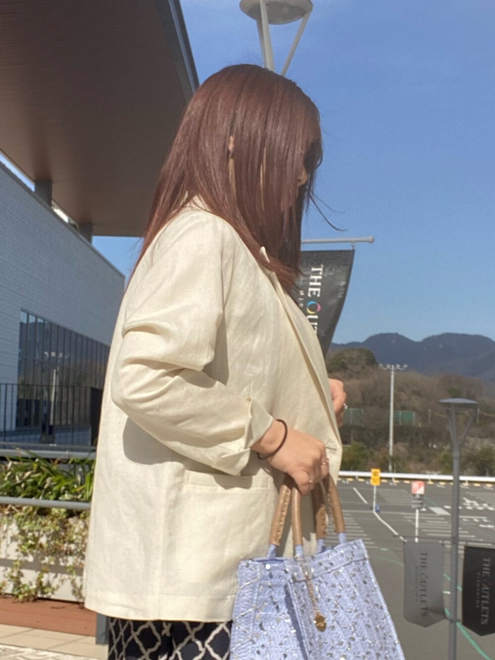 ブラック系のワンピース、ホワイト系のテーラードジャケットを着用したレディースの春コーディネートの5枚目の写真