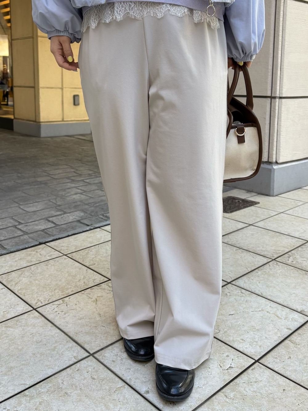 ブルー系のブルゾン、パープル系のニット/セーター、ホワイト系のTシャツ/カットソーを着用したレディースの春コーディネートの7枚目の写真