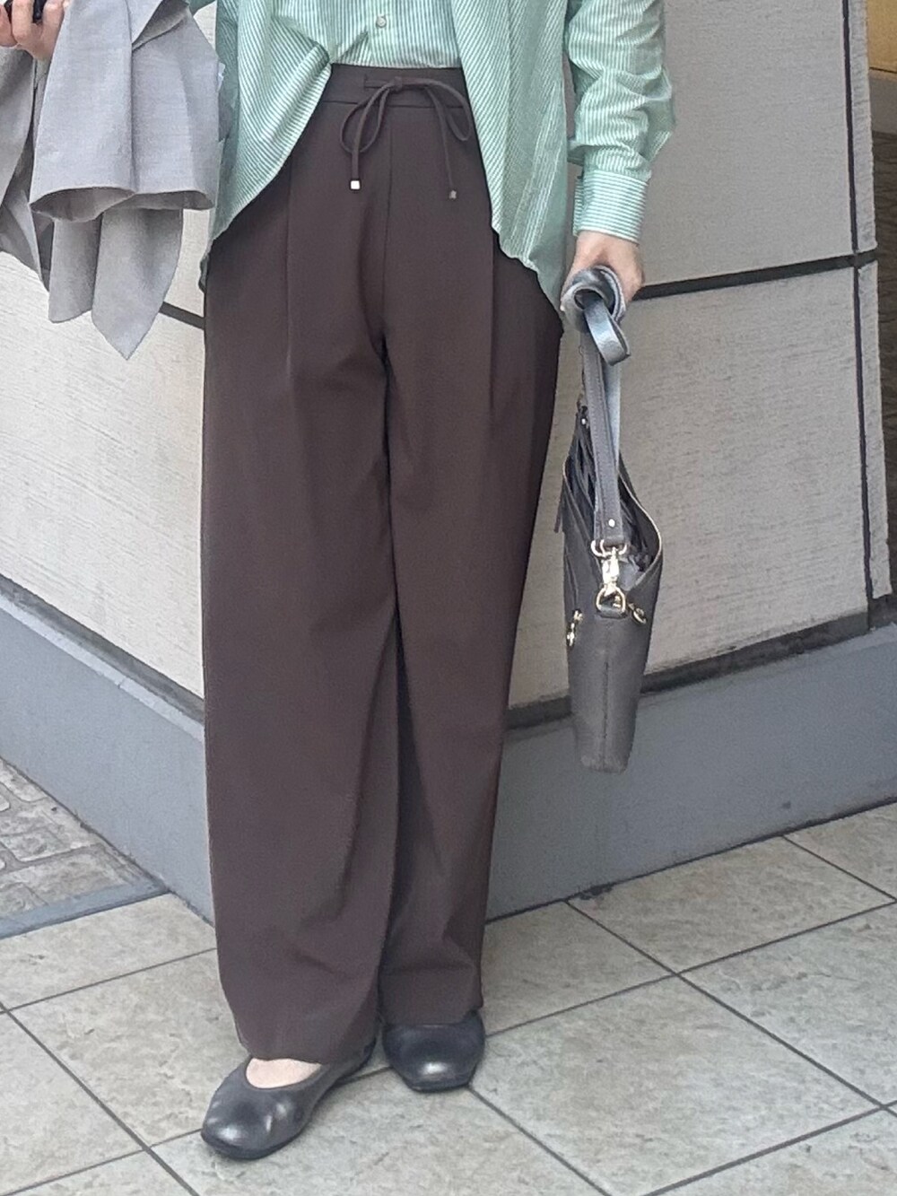 グレー系のショルダーバッグ、ブラウン系のその他パンツ、ベージュ系のダウンジャケット/コートを着用したレディースの春コーディネートの7枚目の写真