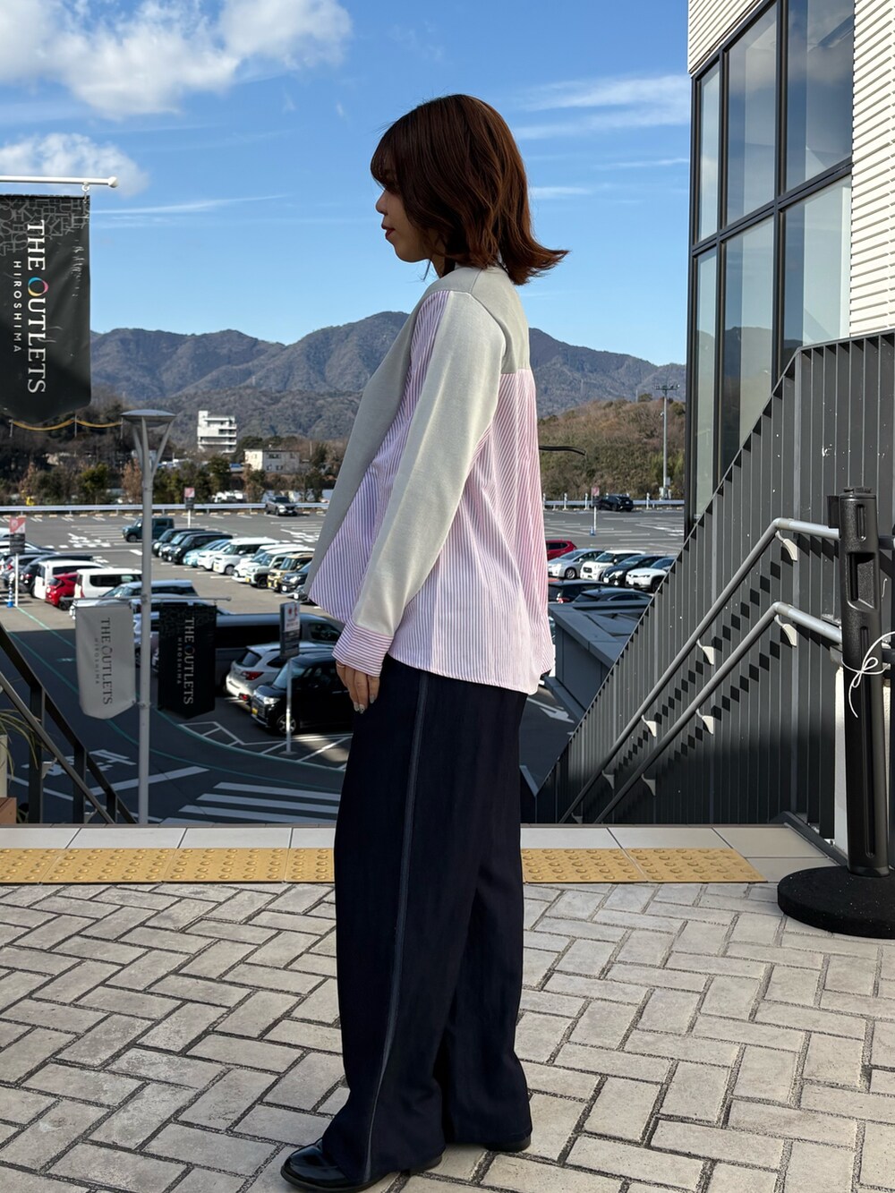 グレー系のニット/セーター、ブルー系のデニムパンツを着用したレディースの冬コーディネートの2枚目の写真