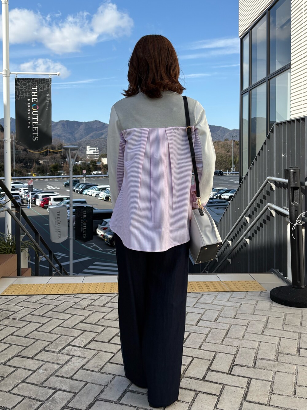 グレー系のニット/セーター、ブルー系のデニムパンツを着用したレディースの冬コーディネートの3枚目の写真