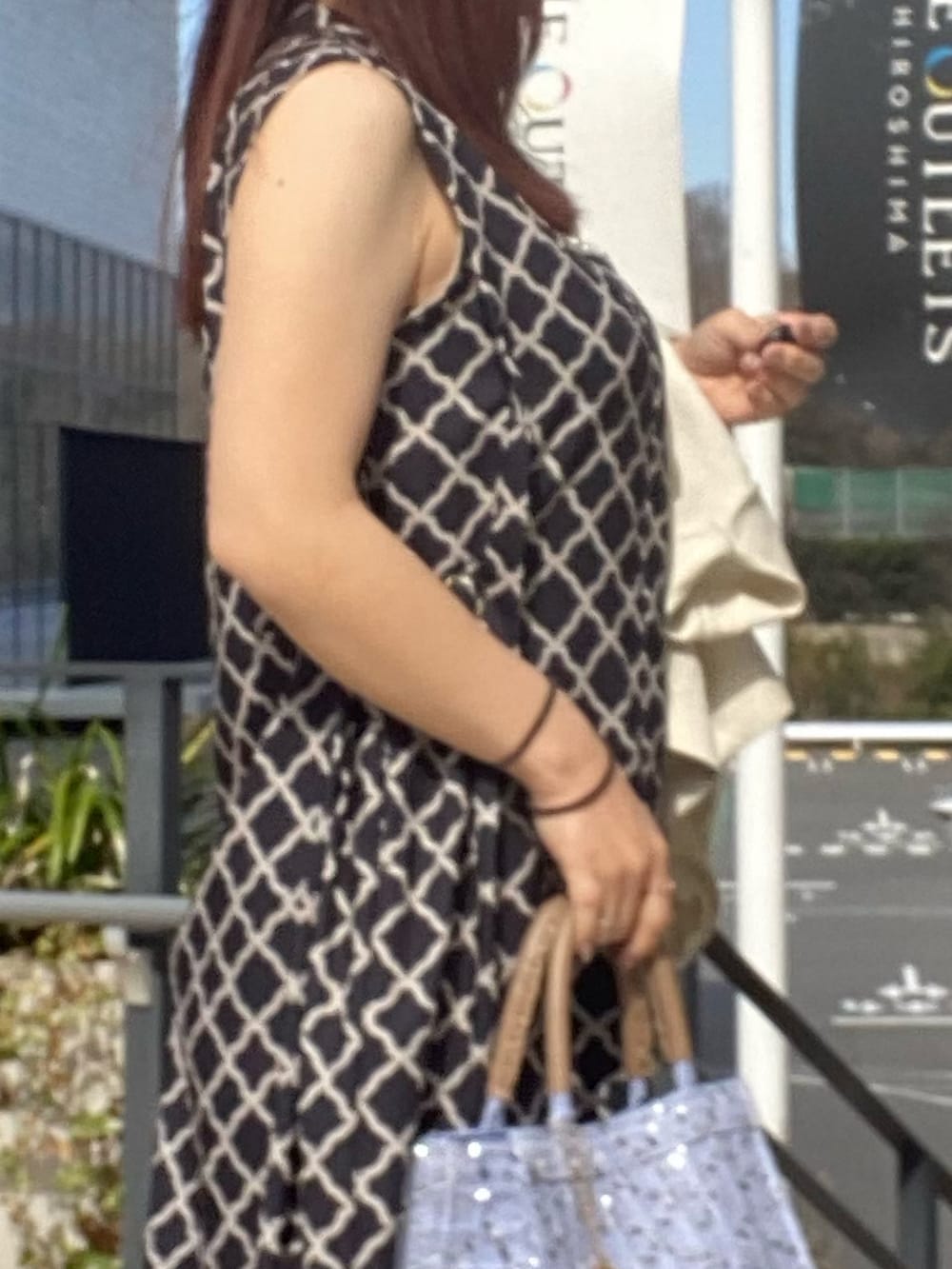 ブラック系のワンピース、ホワイト系のテーラードジャケットを着用したレディースの春コーディネートの4枚目の写真