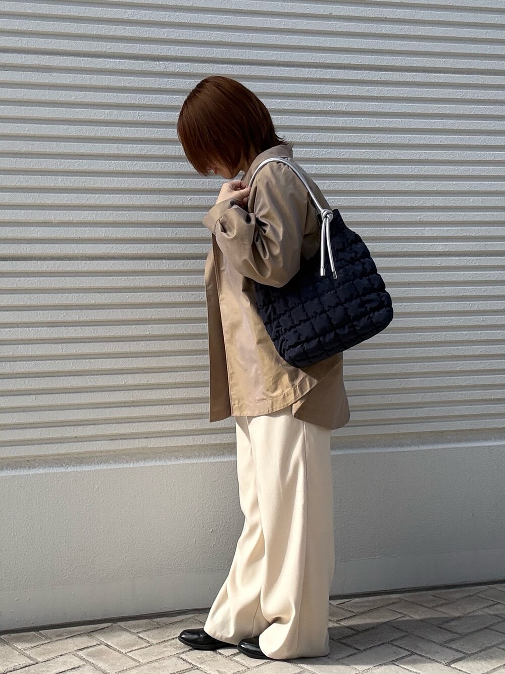 イエロー系のその他アウター、ホワイト系のカーディガン/ボレロ、ホワイト系のその他パンツを着用したレディースの冬コーディネートの2枚目の写真