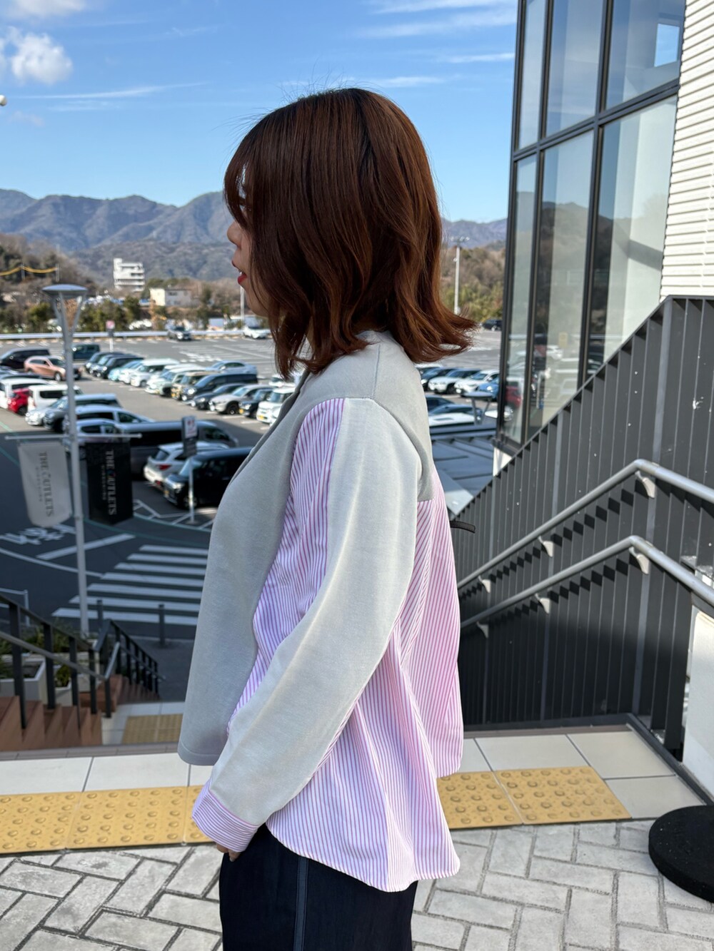 グレー系のニット/セーター、ブルー系のデニムパンツを着用したレディースの冬コーディネートの5枚目の写真