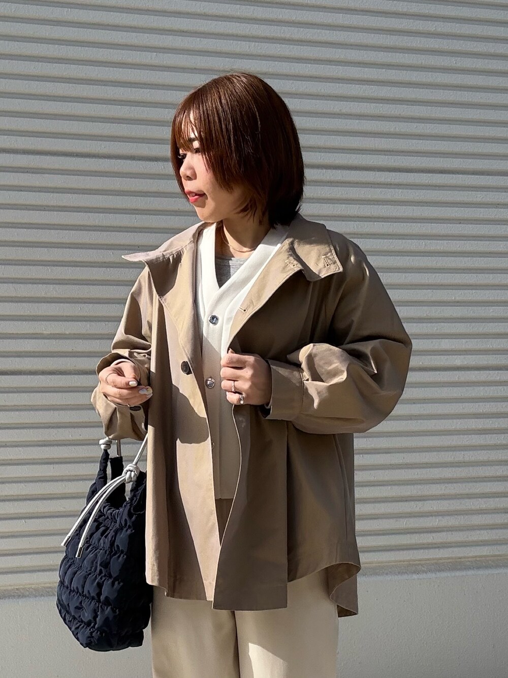 イエロー系のその他アウター、ホワイト系のカーディガン/ボレロ、ホワイト系のその他パンツを着用したレディースの冬コーディネートの4枚目の写真