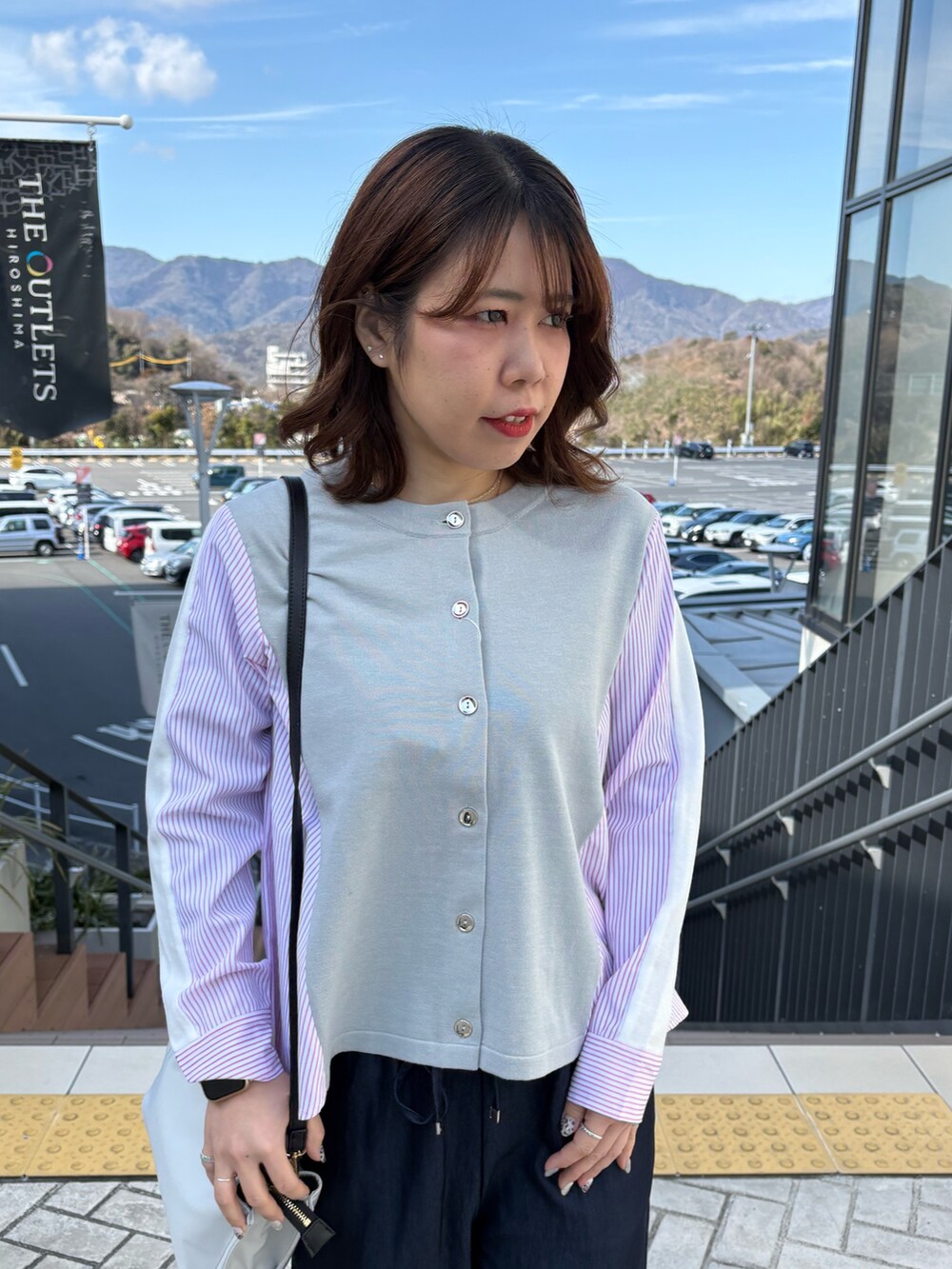 グレー系のニット/セーター、ブルー系のデニムパンツを着用したレディースの冬コーディネートの4枚目の写真