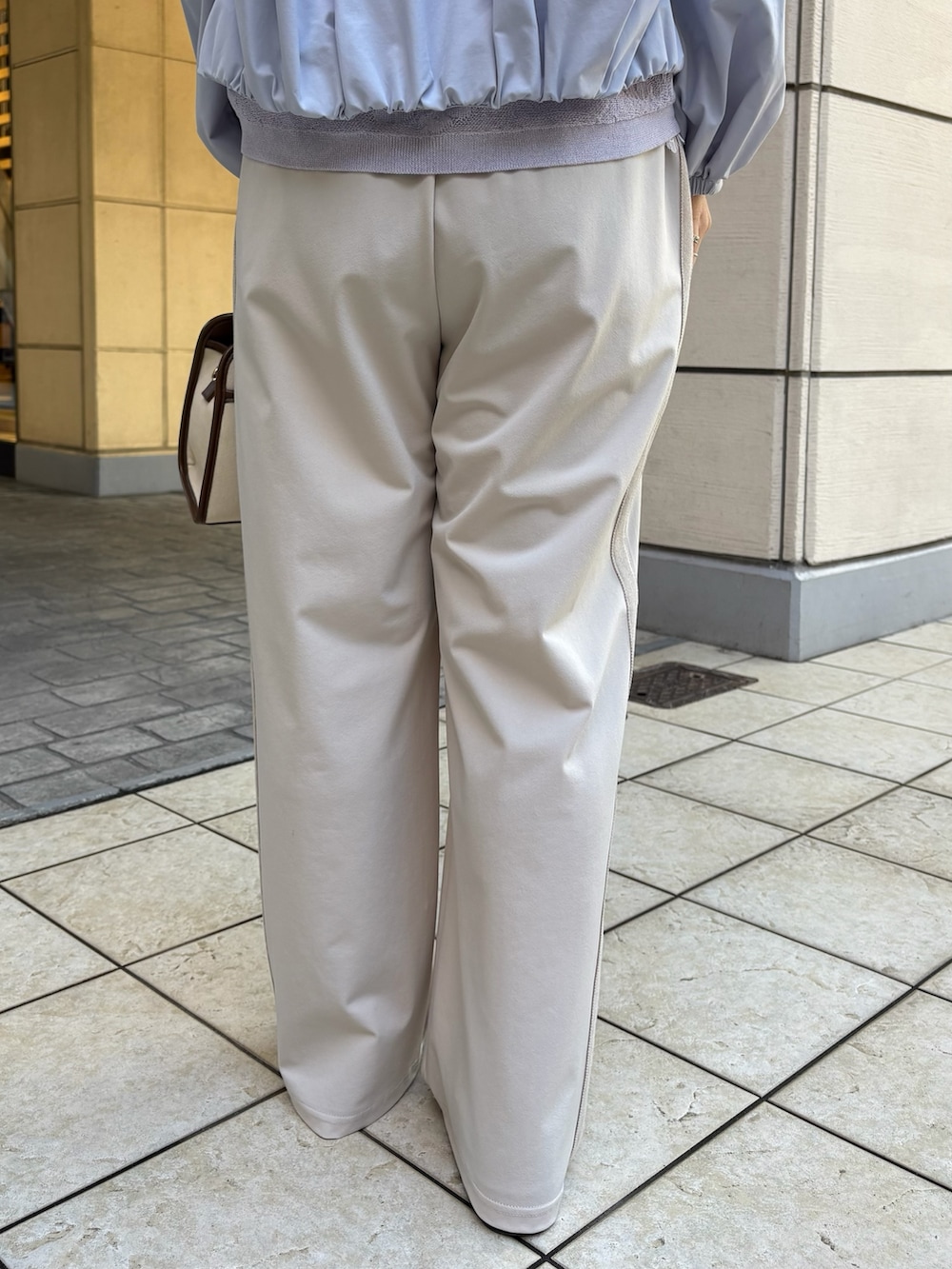 ブルー系のブルゾン、パープル系のニット/セーター、ホワイト系のTシャツ/カットソーを着用したレディースの春コーディネートの9枚目の写真