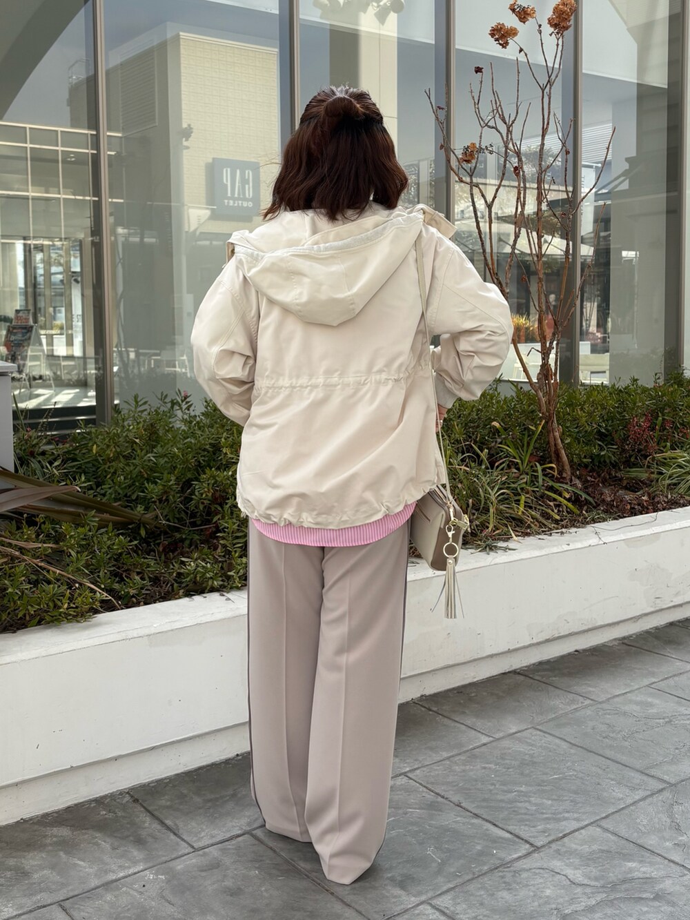 ホワイト系のブルゾン、ピンク系のシャツ/ブラウス、ベージュ系のその他パンツを着用したレディースの冬コーディネートの3枚目の写真