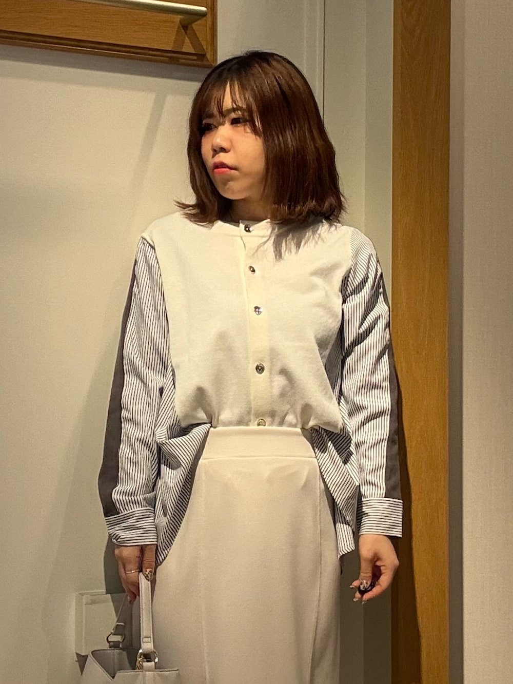 ホワイト系のニット/セーター、ホワイト系のスカートを着用したレディースの冬コーディネートの4枚目の写真