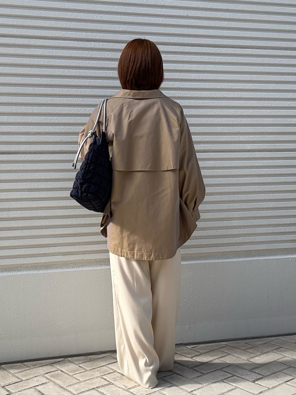 イエロー系のその他アウター、ホワイト系のカーディガン/ボレロ、ホワイト系のその他パンツを着用したレディースの冬コーディネートの3枚目の写真