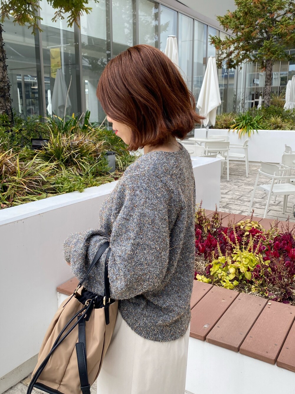 グレー系のニット/セーター、ホワイト系のスカートを着用したレディースの冬コーディネートの5枚目の写真