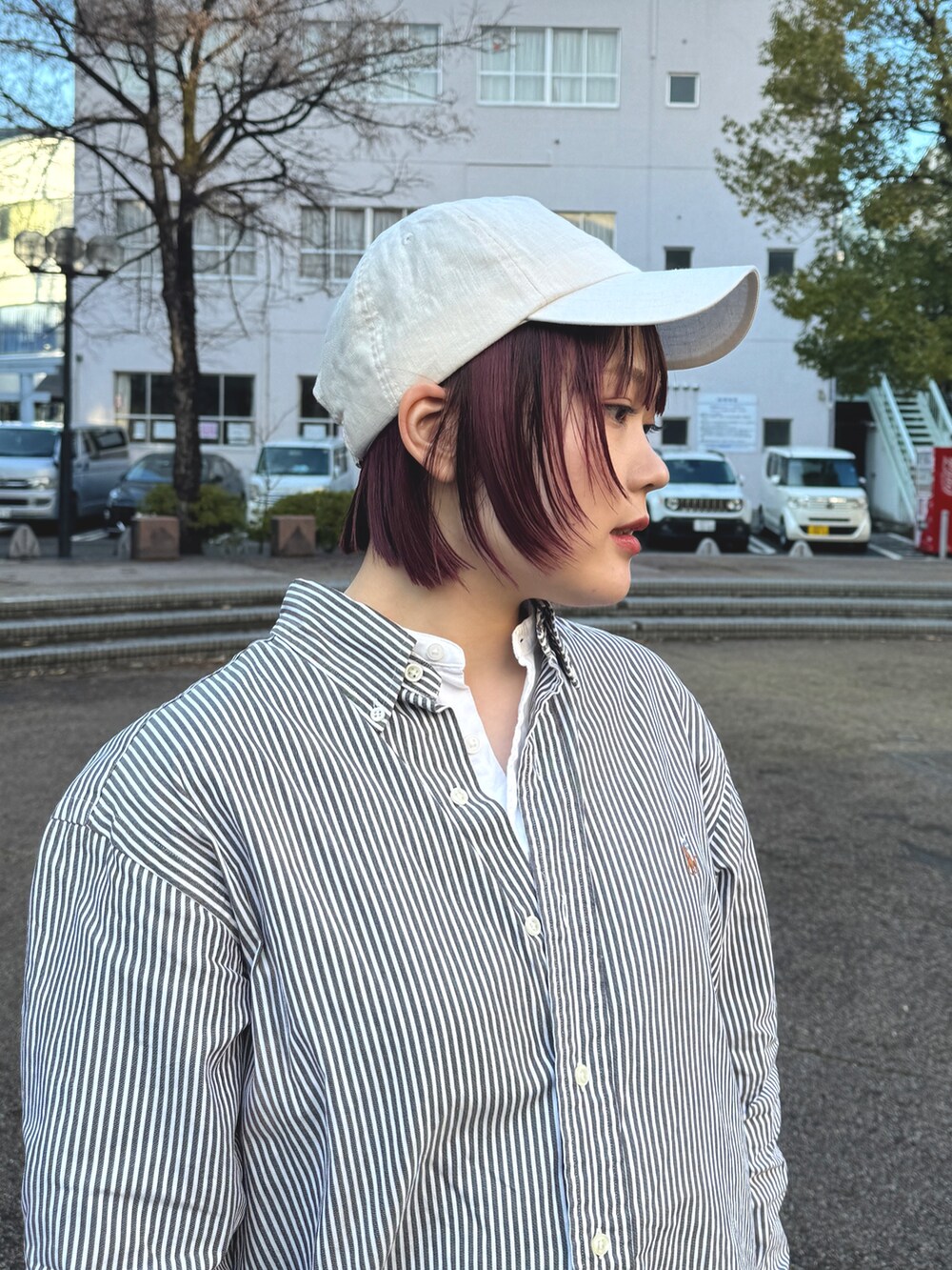 ブラック系のスニーカー、ベージュ系のキャップを着用したレディースの春コーディネートの2枚目の写真