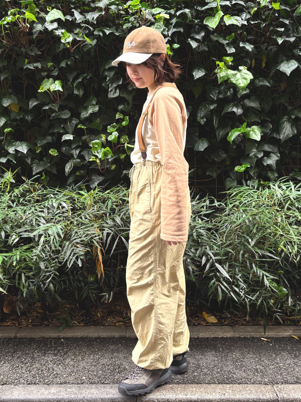 ベージュ系のTシャツ/カットソー、ベージュ系のその他パンツ、ブラウン系のキャップを着用したレディースの春コーディネートの2枚目の写真