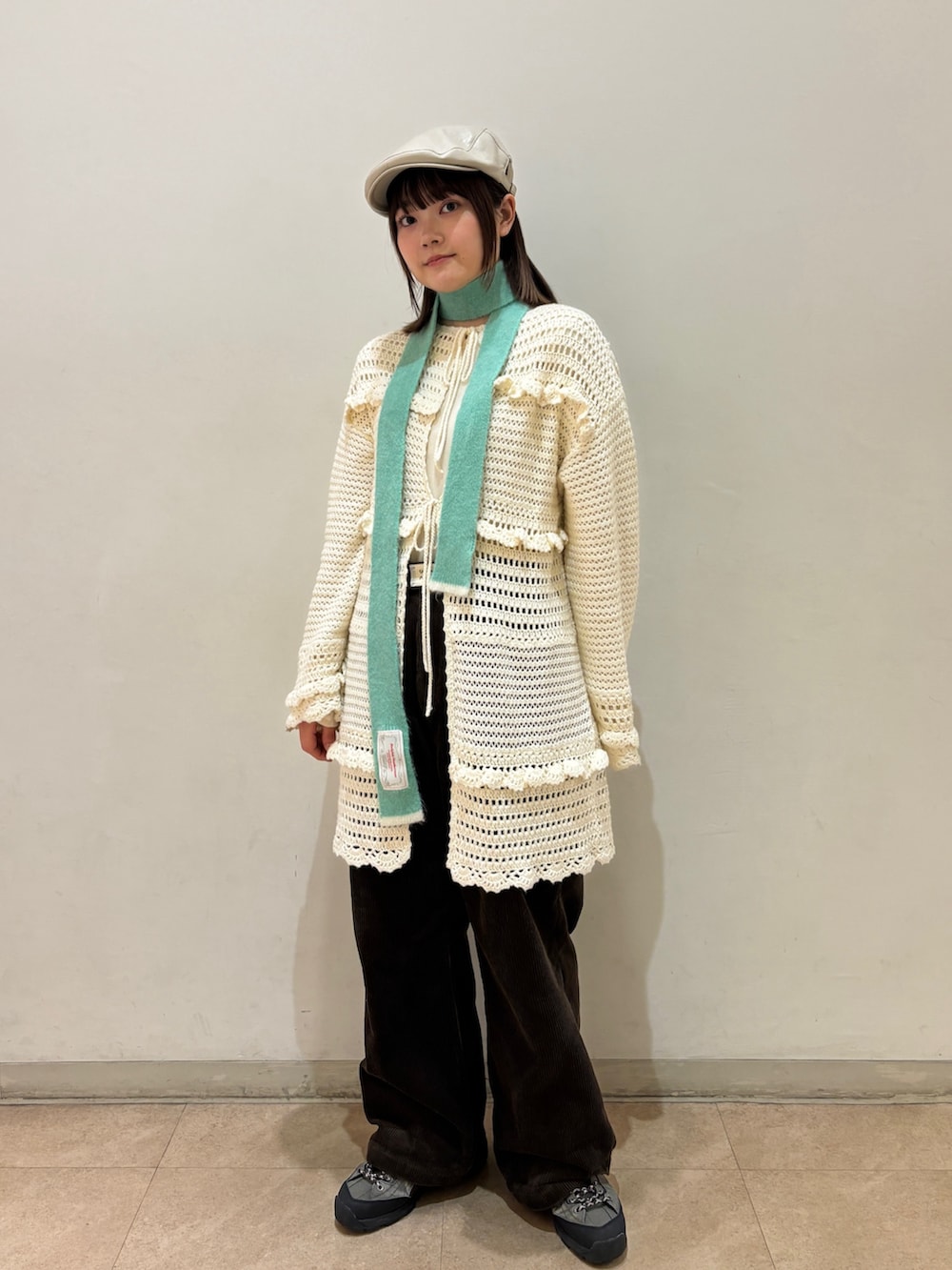 ホワイト系のカーディガン/ボレロ、ブラウン系のその他パンツ、グレー系のスニーカーを着用したレディースの冬コーディネートの2枚目の写真