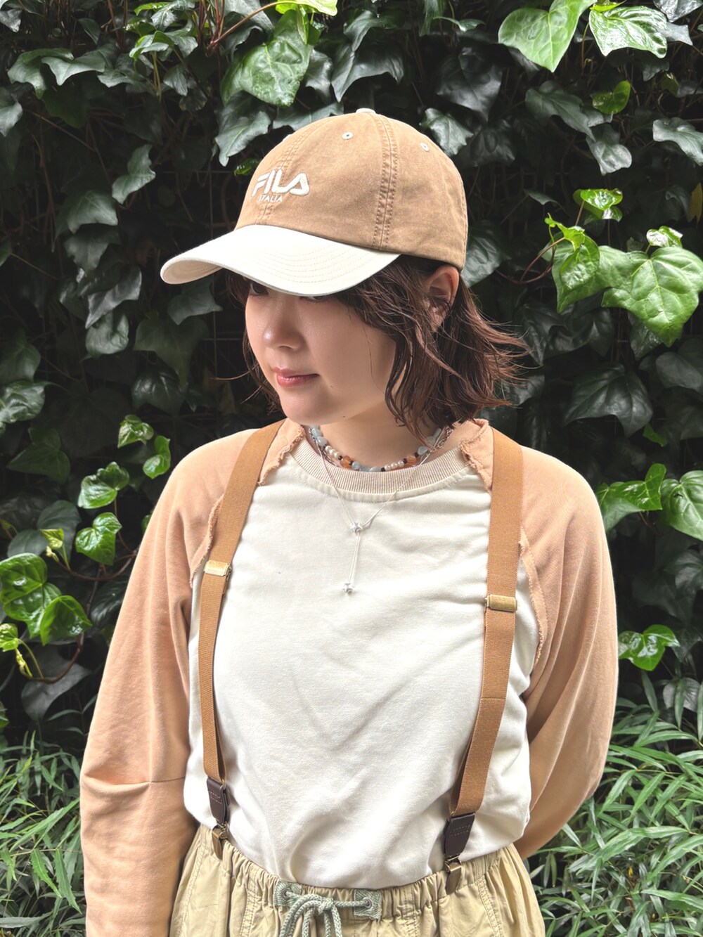 ベージュ系のTシャツ/カットソー、ベージュ系のその他パンツ、ブラウン系のキャップを着用したレディースの春コーディネートの3枚目の写真