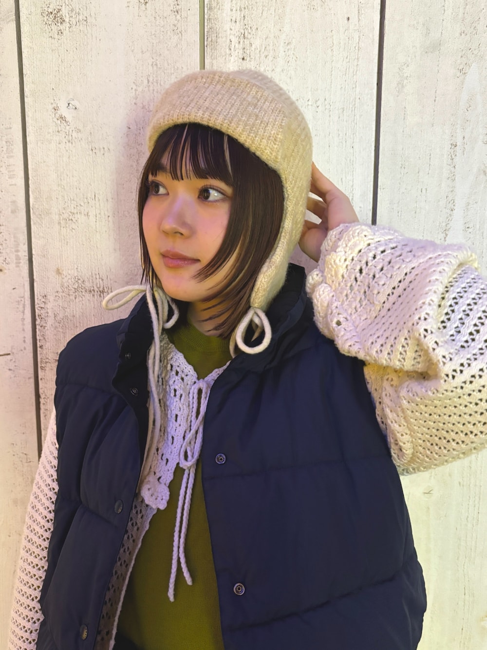 グリーン系のニット/セーター、ベージュ系のスカート、ブルー系のボディバッグ/ウエストポーチを着用したレディースの冬コーディネートの3枚目の写真