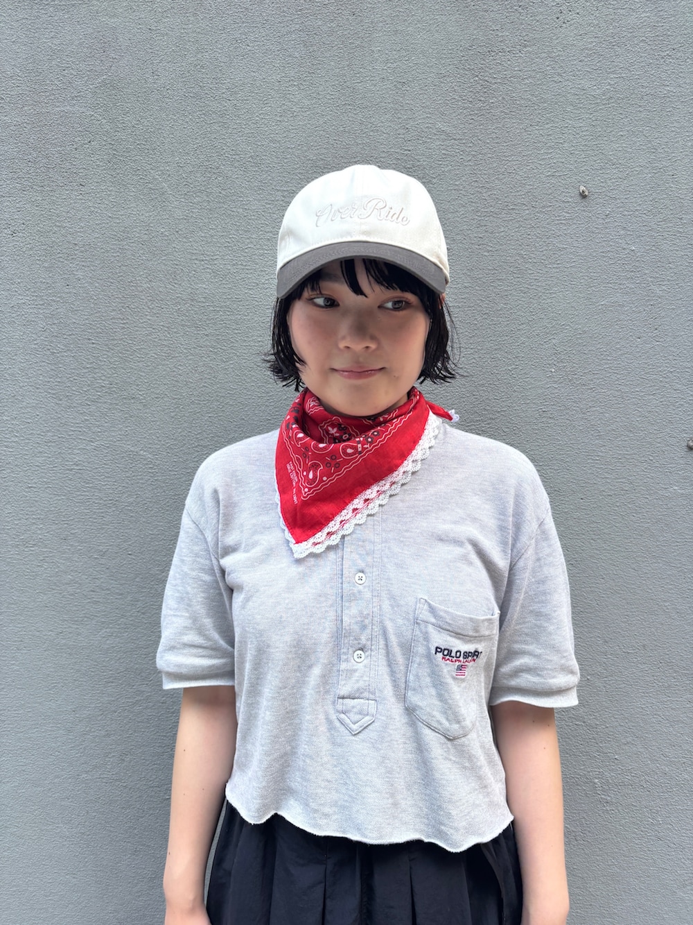 ブラック系のスカート、ブルー系のスニーカー、ブラウン系のキャップを着用したレディースの夏コーディネートの3枚目の写真