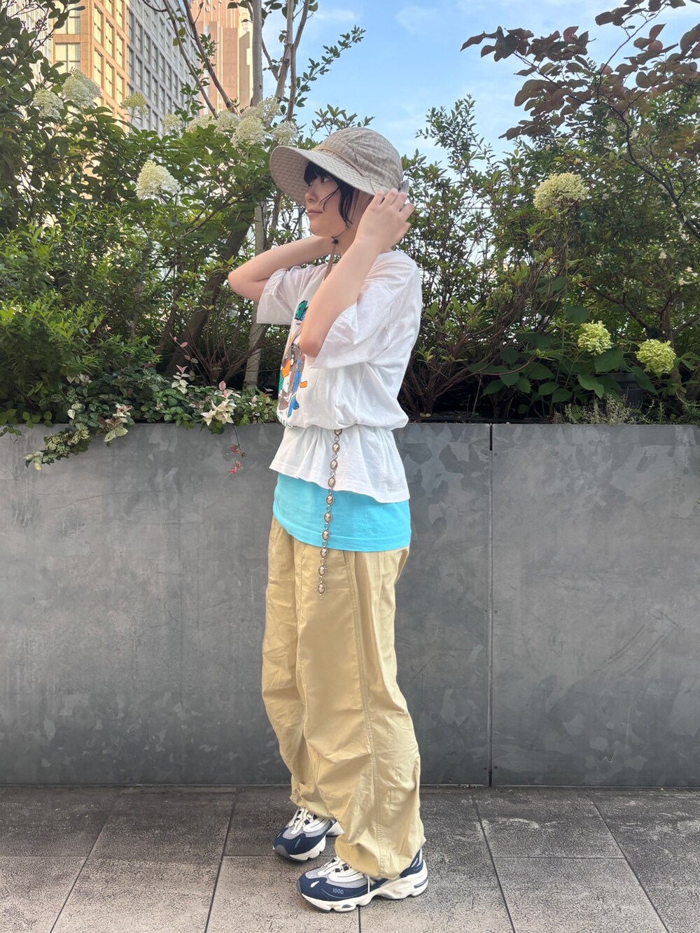 ブルー系のスニーカー、ベージュ系のハットを着用したレディースの夏コーディネートの3枚目の写真
